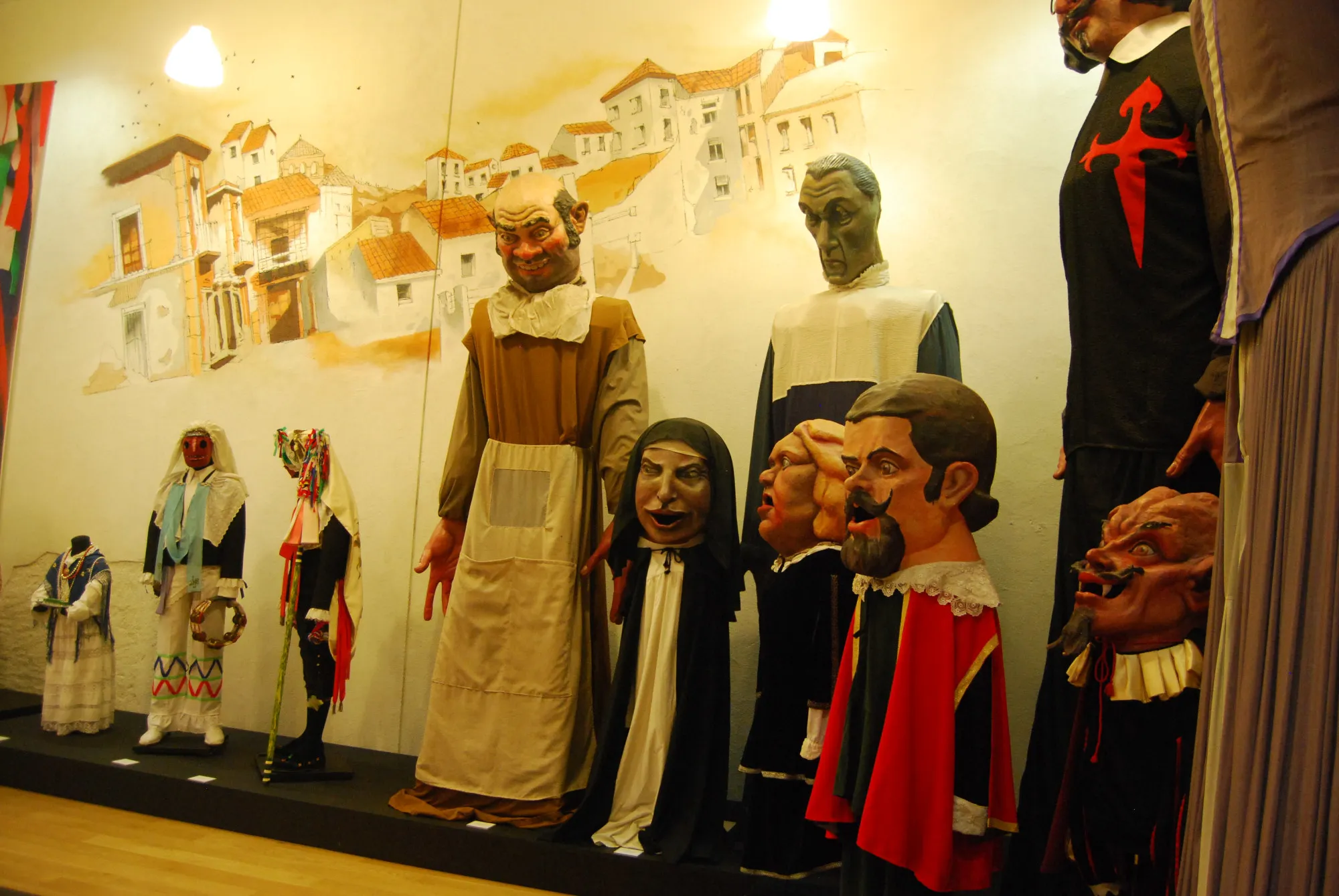 Traditional Spanish folk costumes and masks on display in a museum exhibit