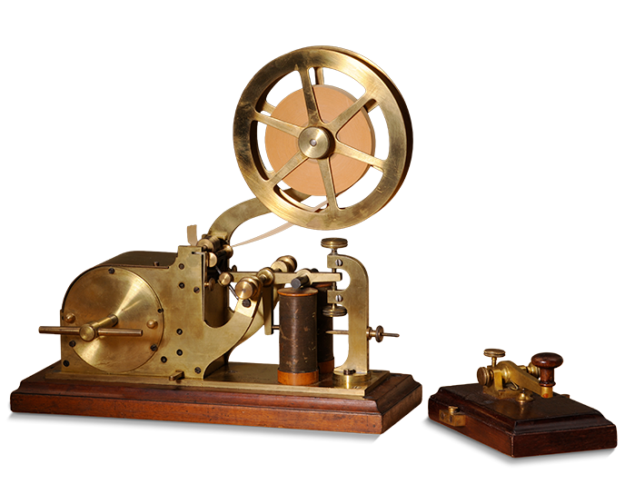 vintage brass telegraph machine with a large wheel and wooden base