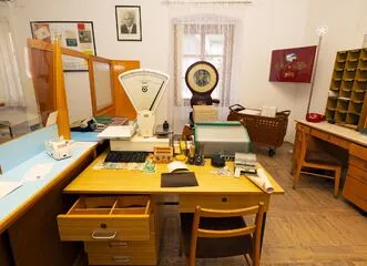Interior of the Postal Museum with a wooden desk, vintage postal scale, and sorting equipment