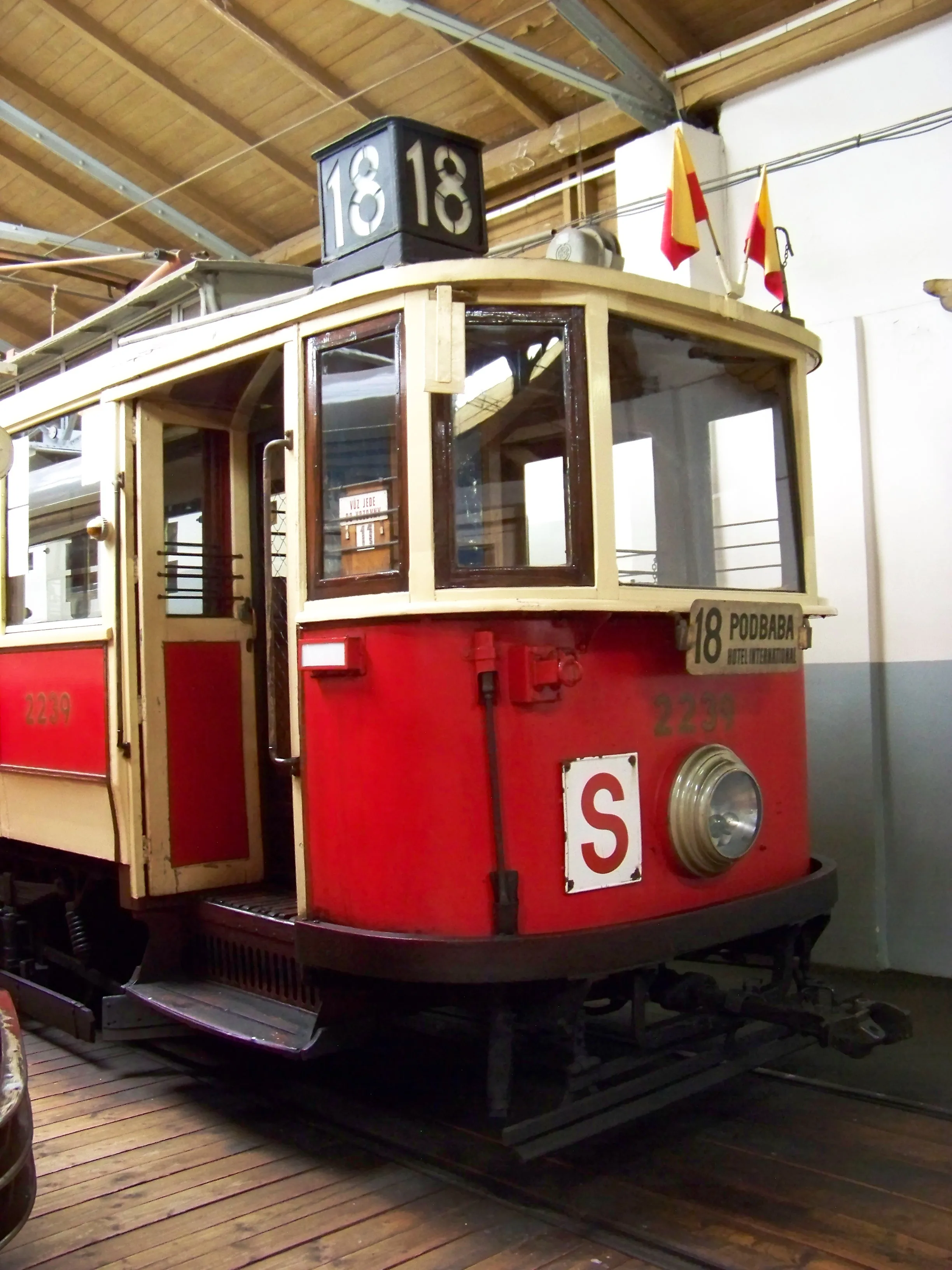 A red and cream vintage tram with destination sign 18 and route S, displayed indoors in a museum