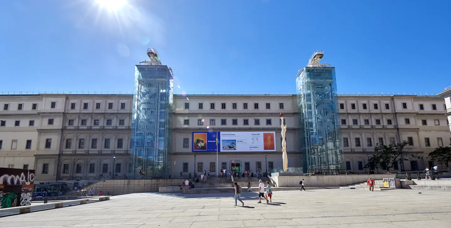 El Centro de Artes Reina Sofía con dos torres de cristal y una gran pancarta en la fachada