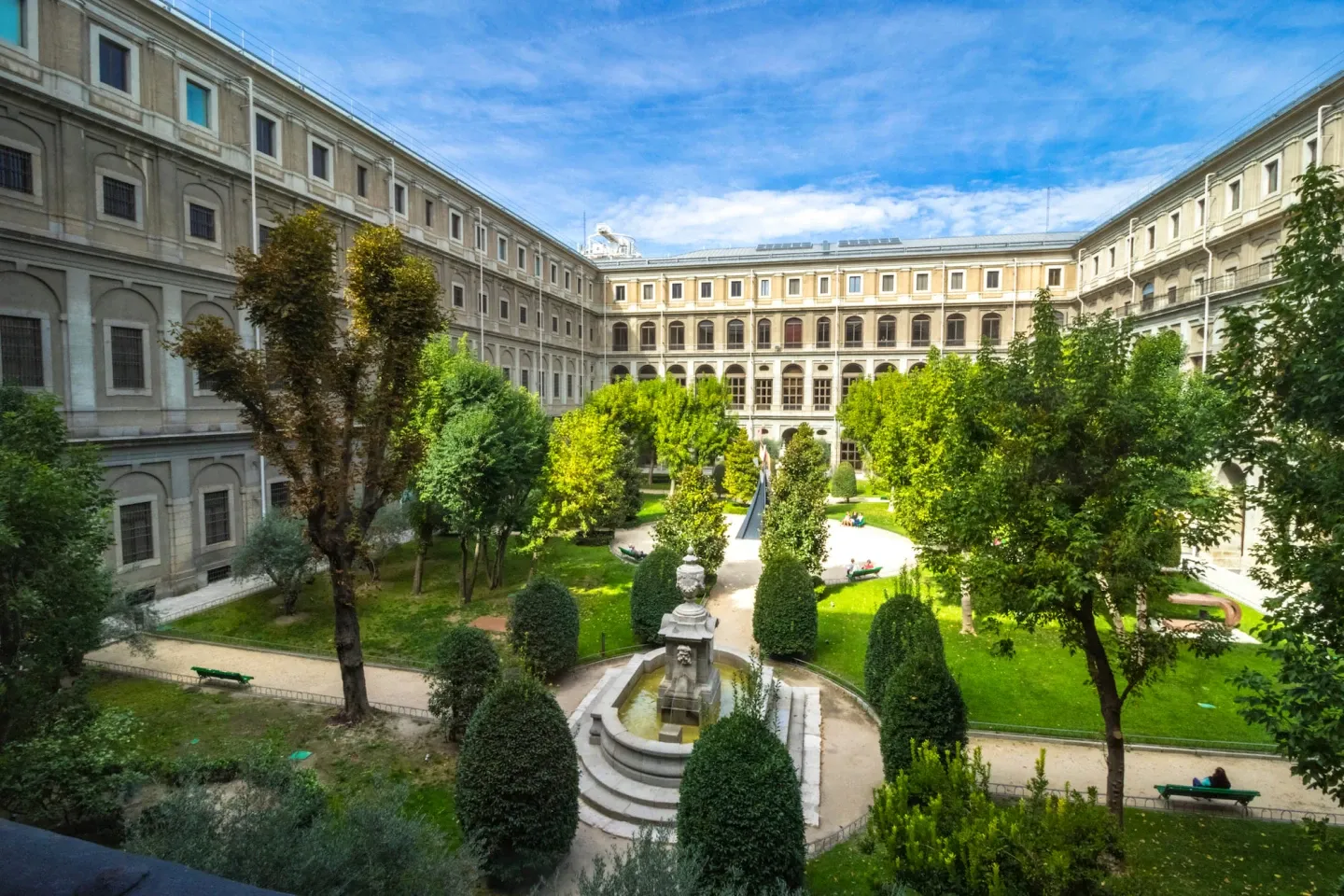 patio con fuente, árboles verdes y arquitectura de edificios clásicos