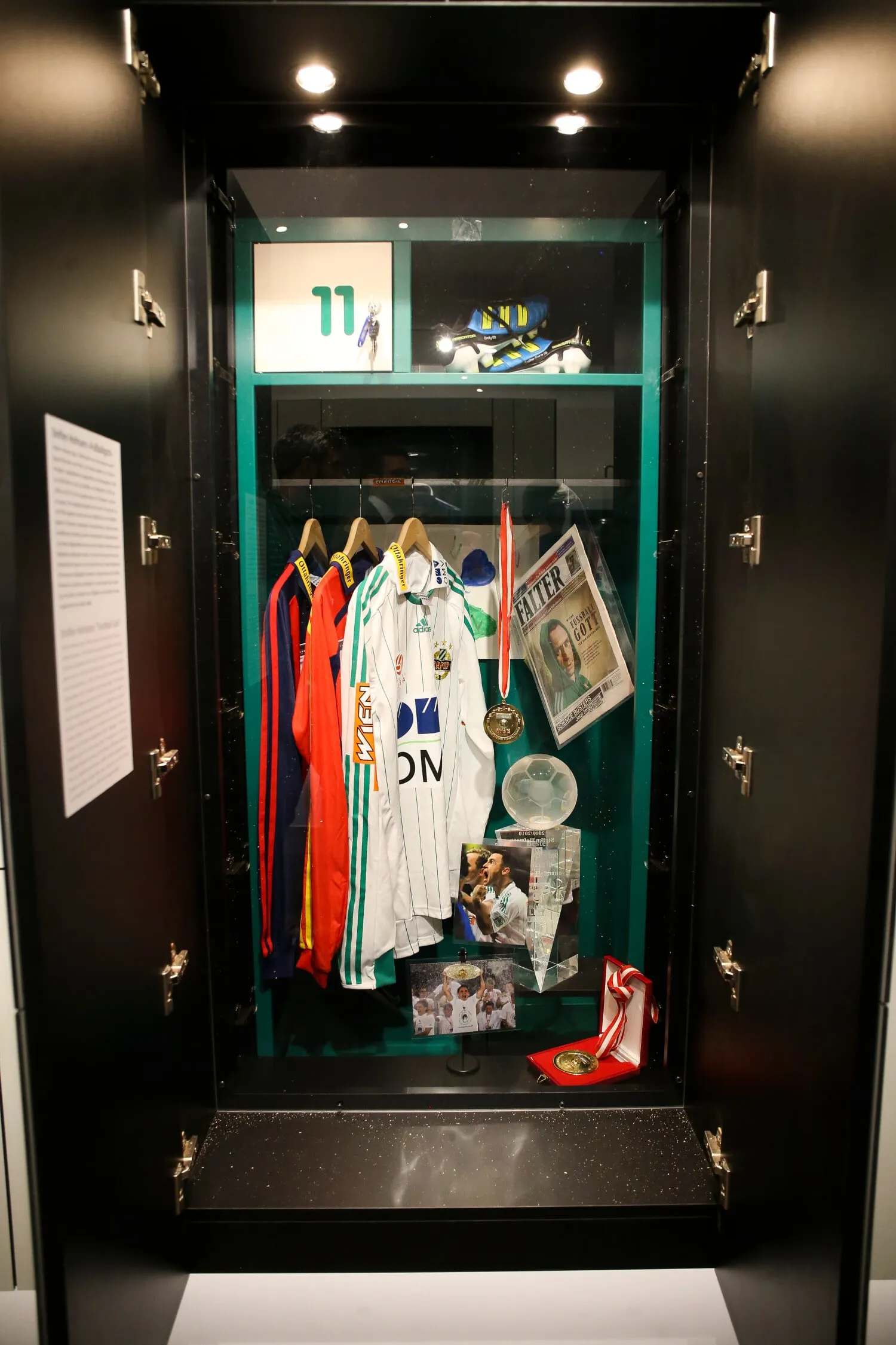 Vitrine met voetbalshirts, een trofee en memorabilia in het Rapideum museum