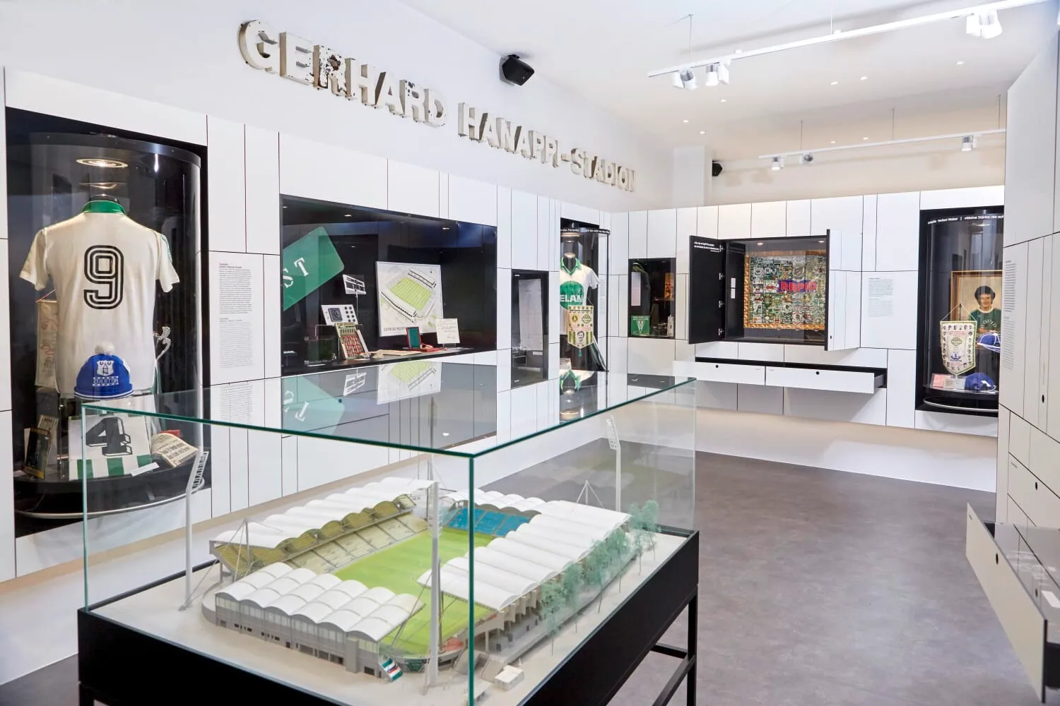 interieur van het Rapideum museum met glazen vitrines, voetbalmemorabilia en wit panelen
