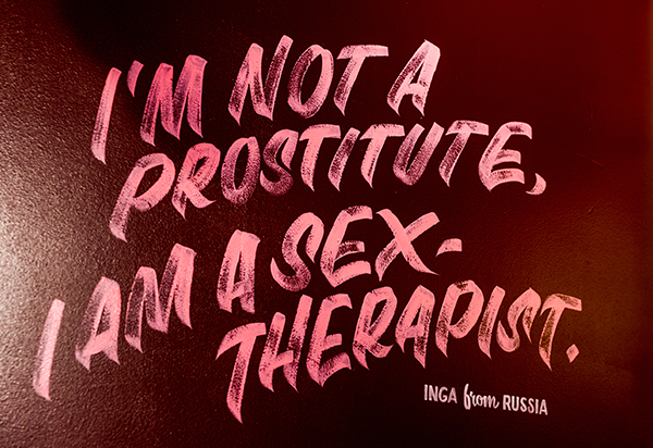 Roze handgeschreven tekst op donkere achtergrond met de tekst 'Ik ben geen prostituee, ik ben een sekstherapeute.' met daaronder de vermelding 'INGA from RUSSIA'