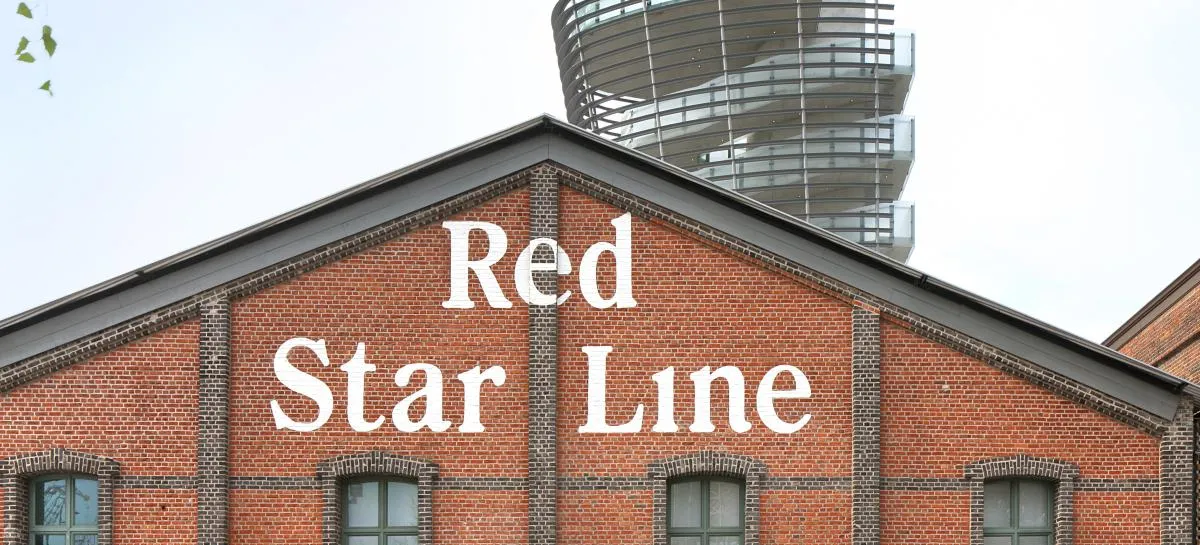 Fachada de ladrillo del Red Star Line Museum con grandes letras blancas y una torre moderna que se alza detrás del tejado.