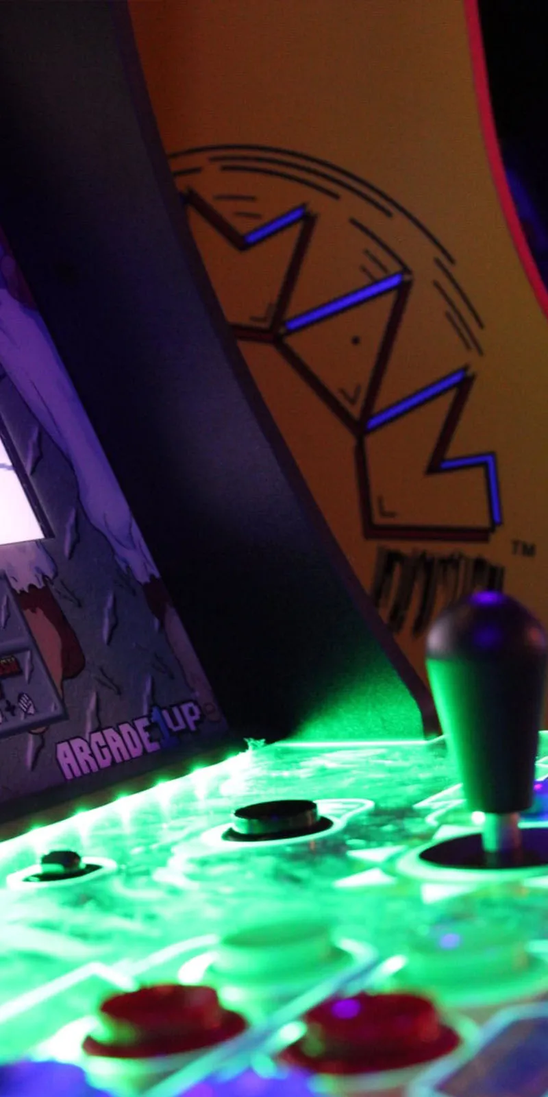 primer plano de una cabina de juegos arcade retro con botones y joystick iluminados