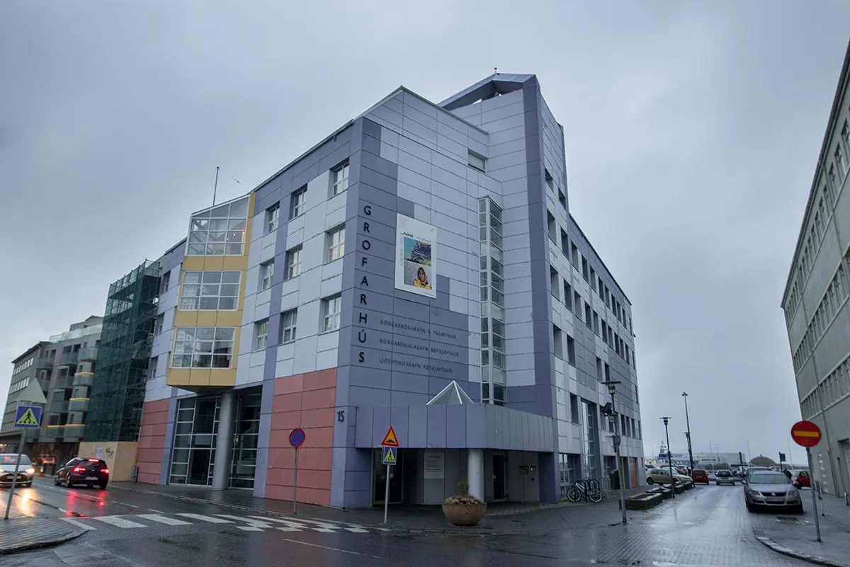 Exterior del edificio Grófarhús con revestimiento púrpura y rosa y señalización vertical, sede del Museo de la Fotografía de Reykjavík.
