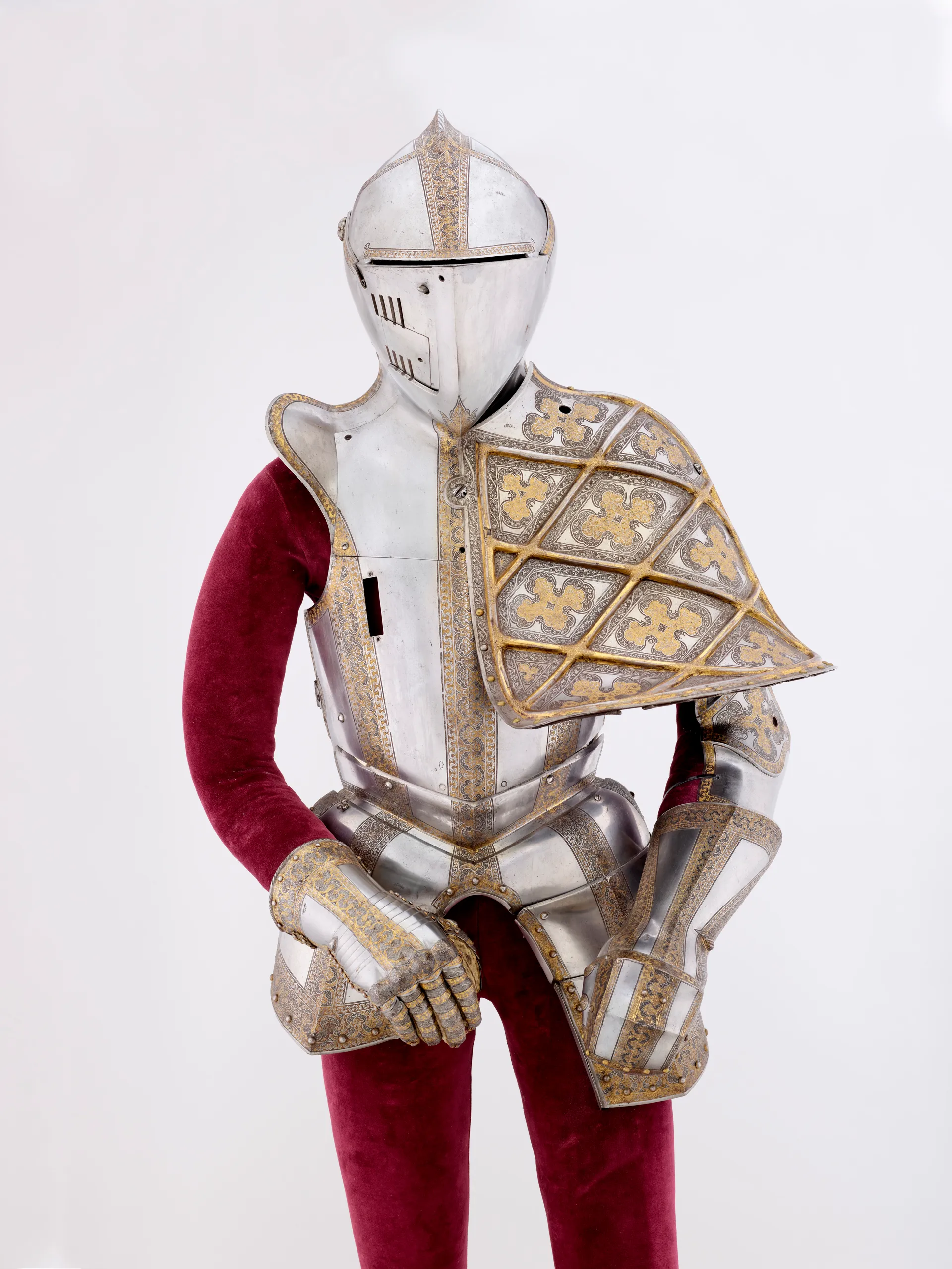 ornate suit of armor with gold detailing and red velvet lining