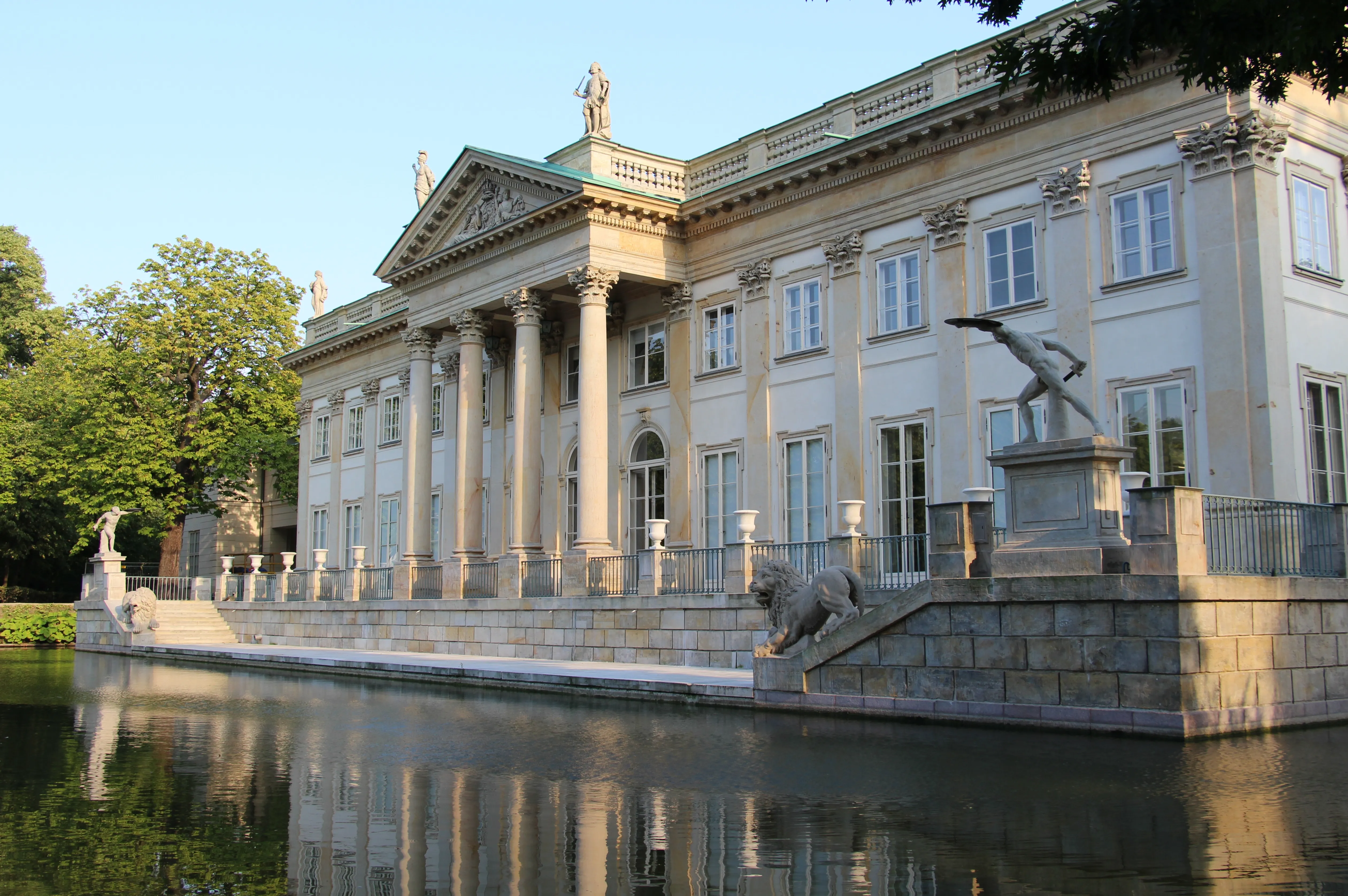 Neoclassical palace with columns and statues reflected in water