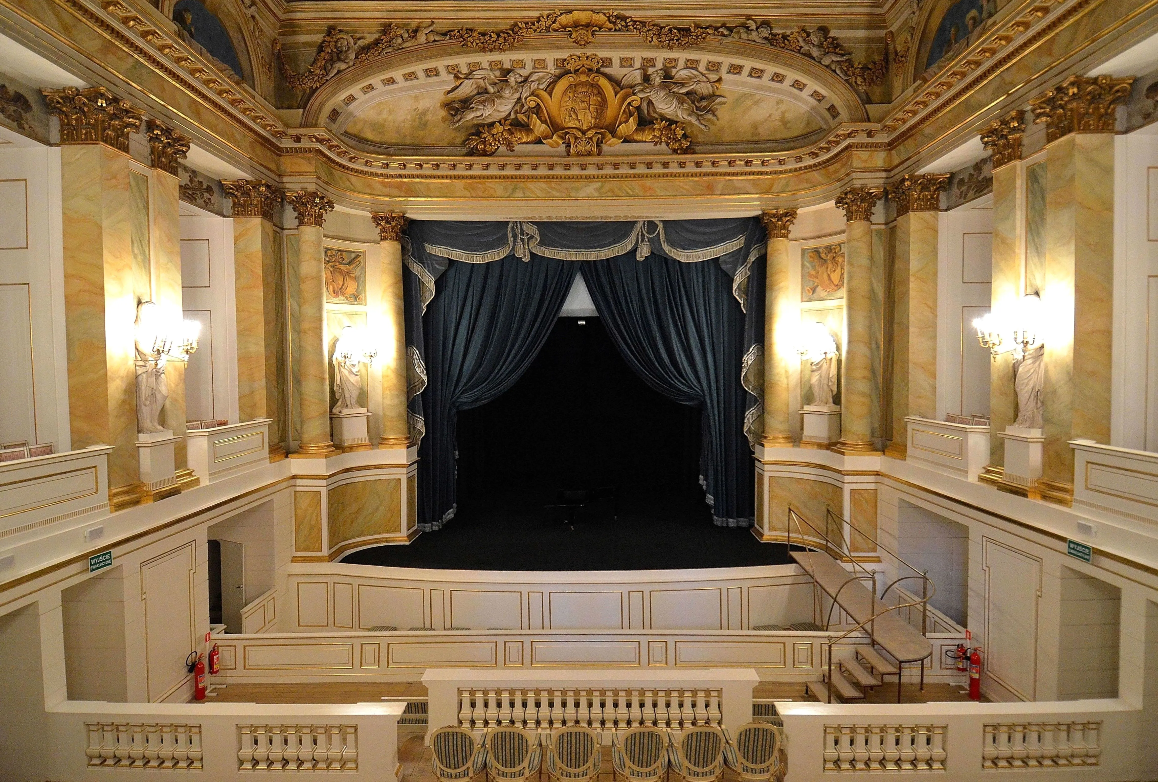 Sierlijk theaterinterieur met blauwe gordijnen, vergulde muren en klassieke sculpturen