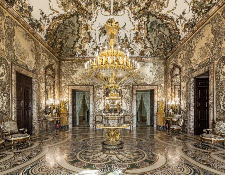 Sierlijke ontvangsthal met een grote kroonluchter, fresco op het plafond en marmeren vloer