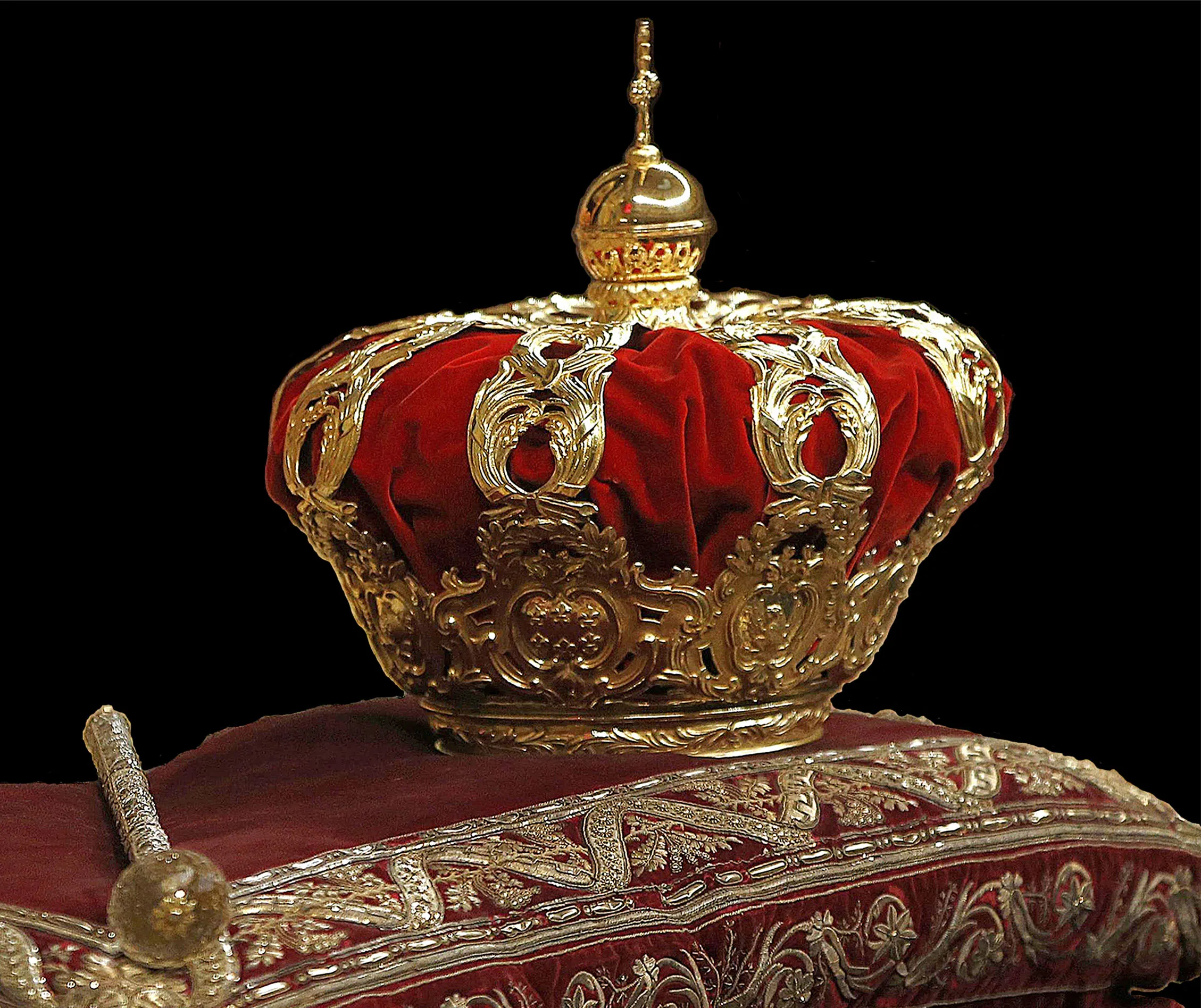 Ornamentele gouden kroon met rode fluwelen voering op een decoratief kussen