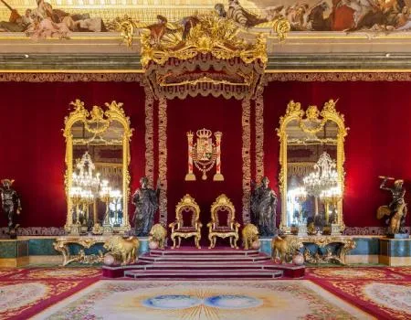 Sierlijk interieur van het Koninklijk Paleis van Madrid met gouden tronen, rode muren en een versierd plafond