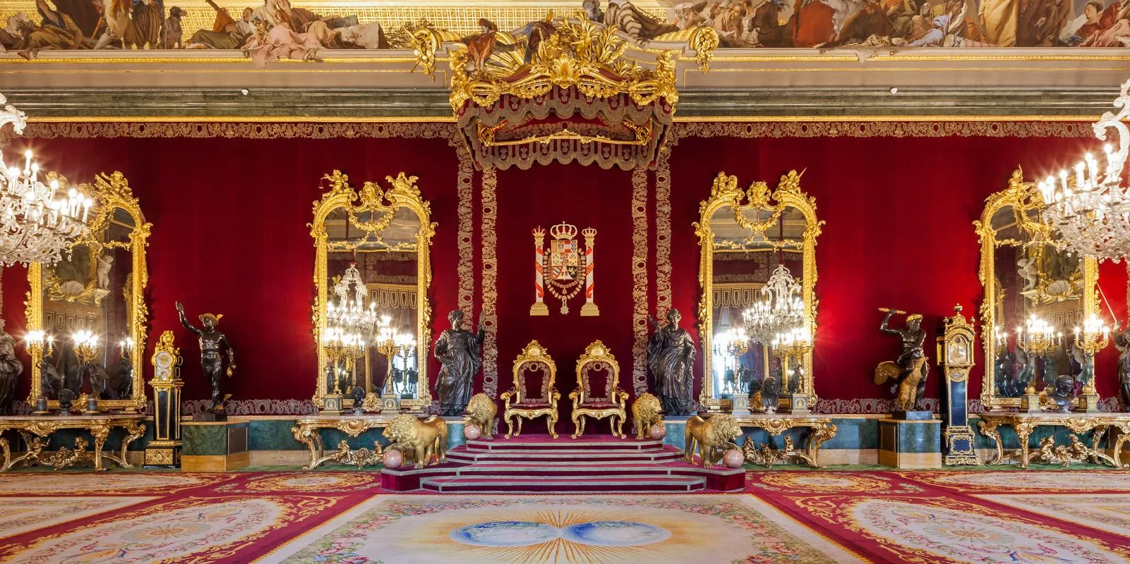 Ornate troonzaal met gouden tronen, rode muren, grote spiegels en kroonluchters