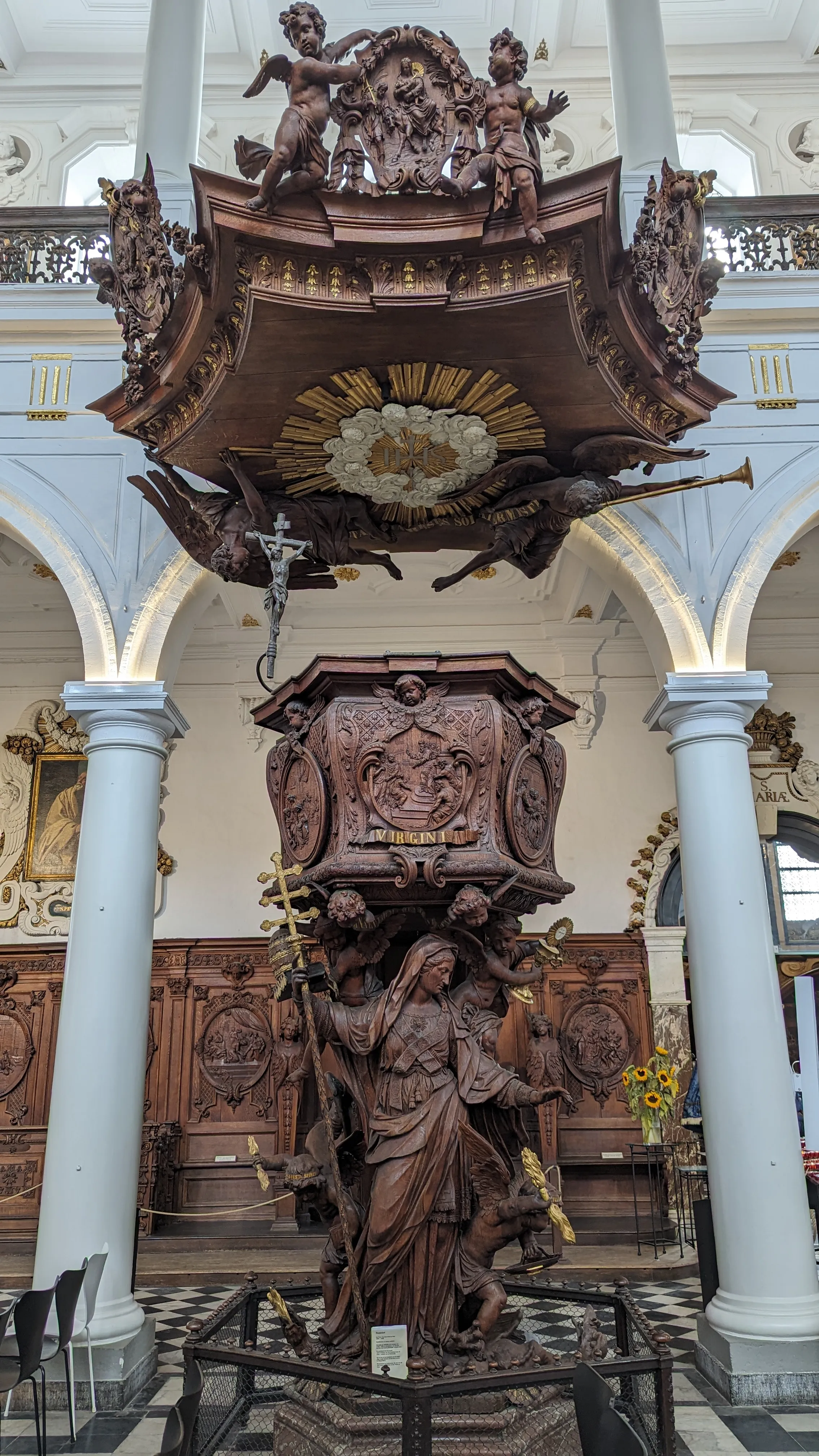 Rijkversierde barokke houten preekstoel met gebeeldhouwde religieuze figuren, cherubijntjes en uitgebreide decoraties in de Sint-Carolus Borromeuskerk