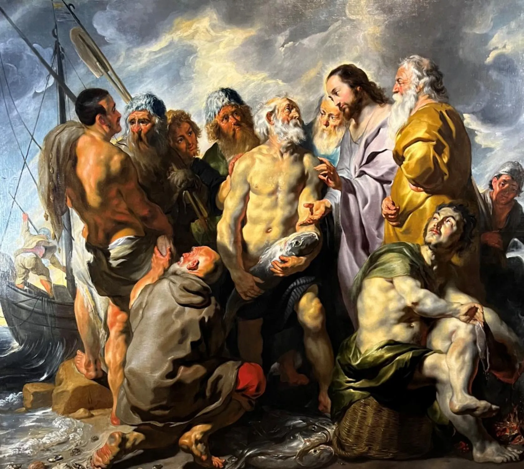 Óleo que representa una escena bíblica con varias figuras en la orilla, incluidos Jesús y unos pescadores con una gran captura de peces, con un barco al fondo.