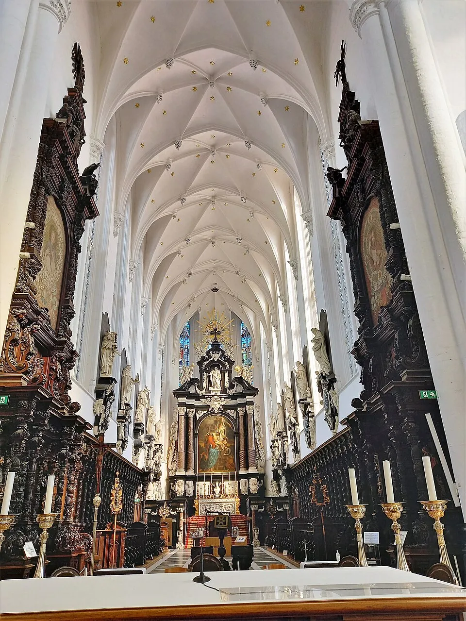 Interior de la nave de la Saint Paul's Church, que muestra techos abovedados blancos, altares laterales de madera oscura y ornamentada, y el altar principal al fondo.
