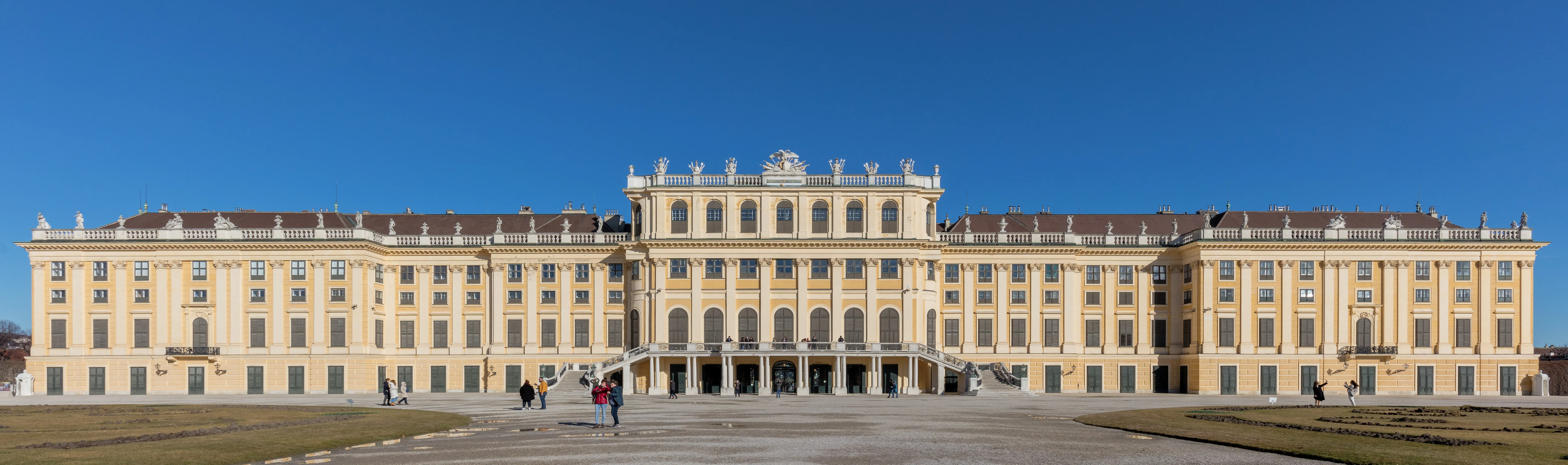 Schönbrunn Palace with its long yellow facade and central entrance under a blue sky