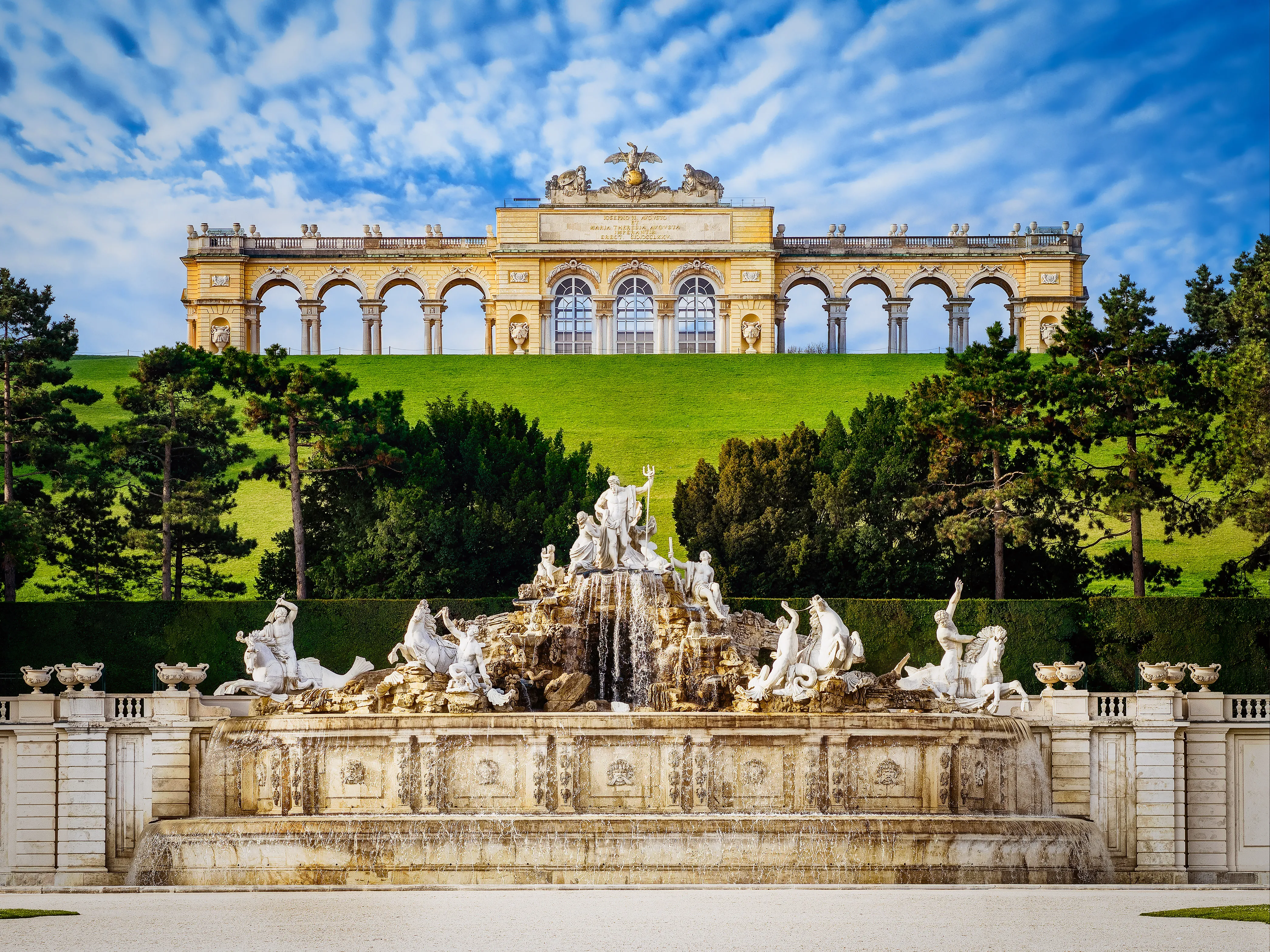 Neptune Fountain with sculptures and the Gloriette building in the background at Schönbrunn Palace