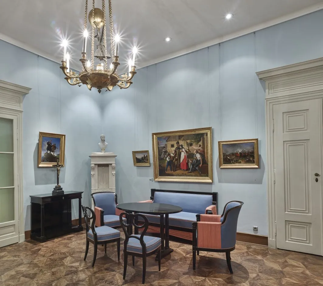 Een elegante ontvangsthal met lichtblauwe muren, een kroonluchter, schilderijen en klassiek meubilair