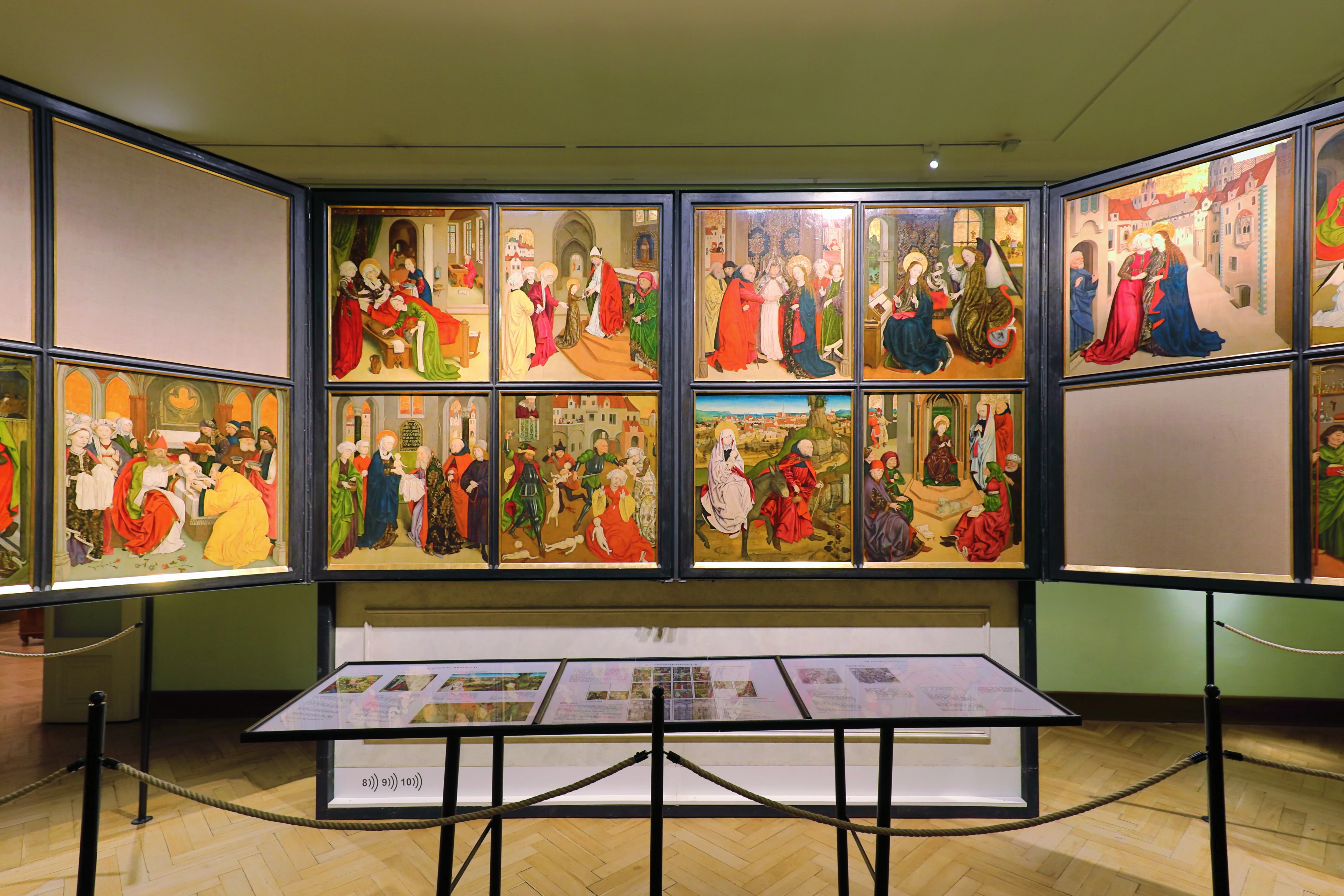 gebogen wanddisplay met historische schilderijen in een museumgalerij
