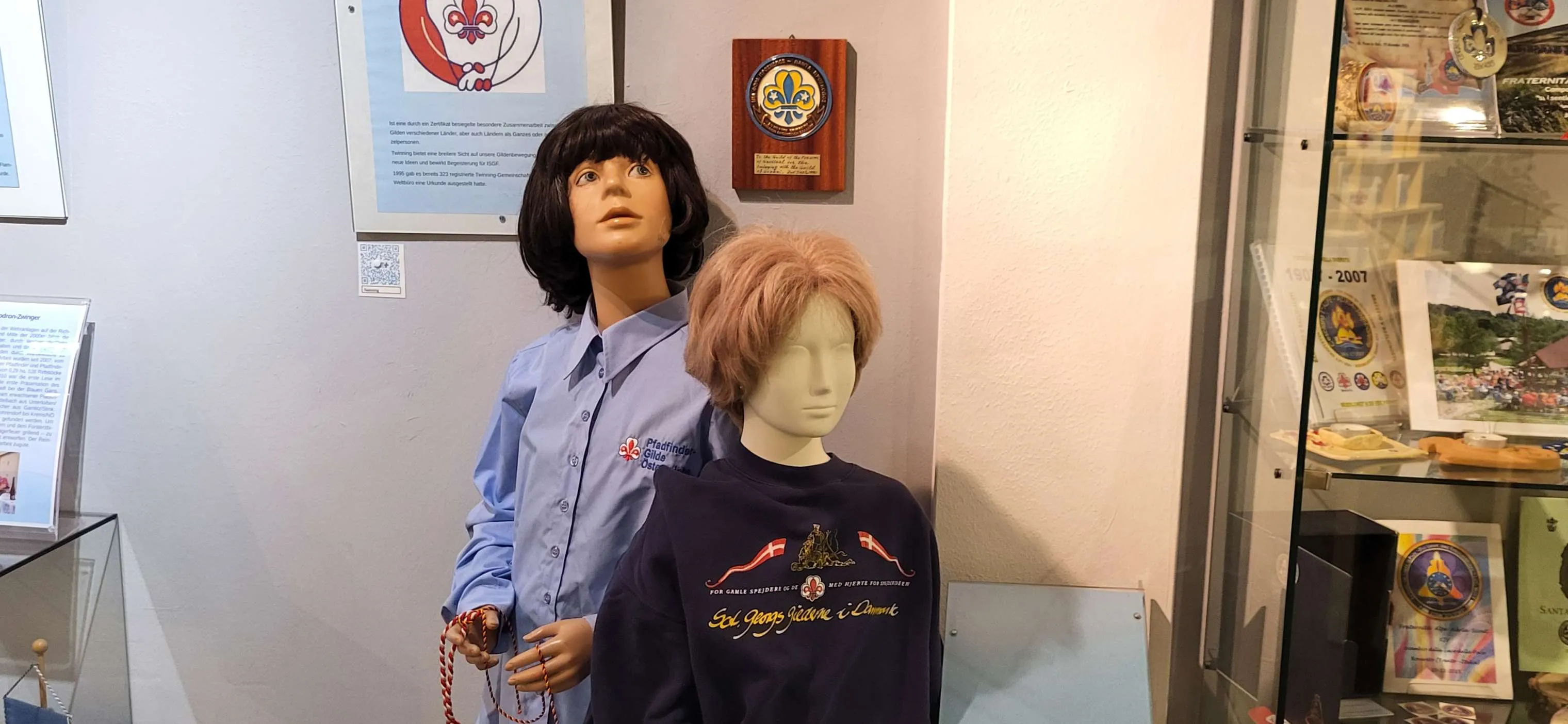 Two mannequins in scouting uniforms displayed in a museum exhibit