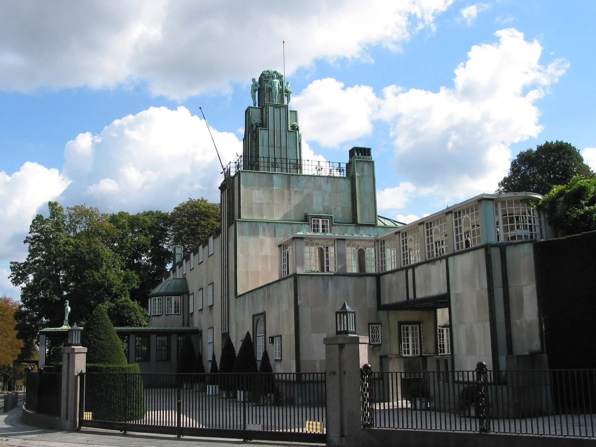 The Secession building with a green copper dome and modernist architecture under a blue sky with white clouds