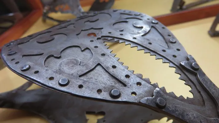 Close-up van een decoratief metalen object met uitgesneden patronen en tandwielranden