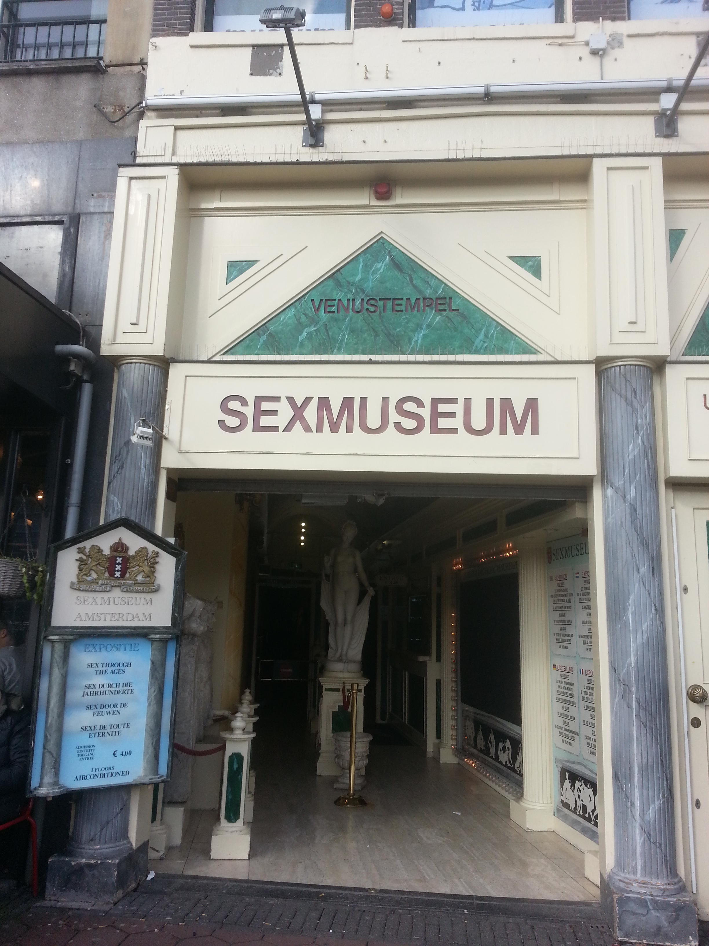 Entrance to the Sex Museum Amsterdam with a sign above the doorway and a statue inside