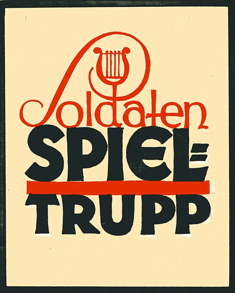 Un letrero vintage con letras rojas y negras sobre un fondo crema, que presenta el texto 'Soldaten Spiel Trupp' y un símbolo de lira encima de la palabra 'Soldaten'.