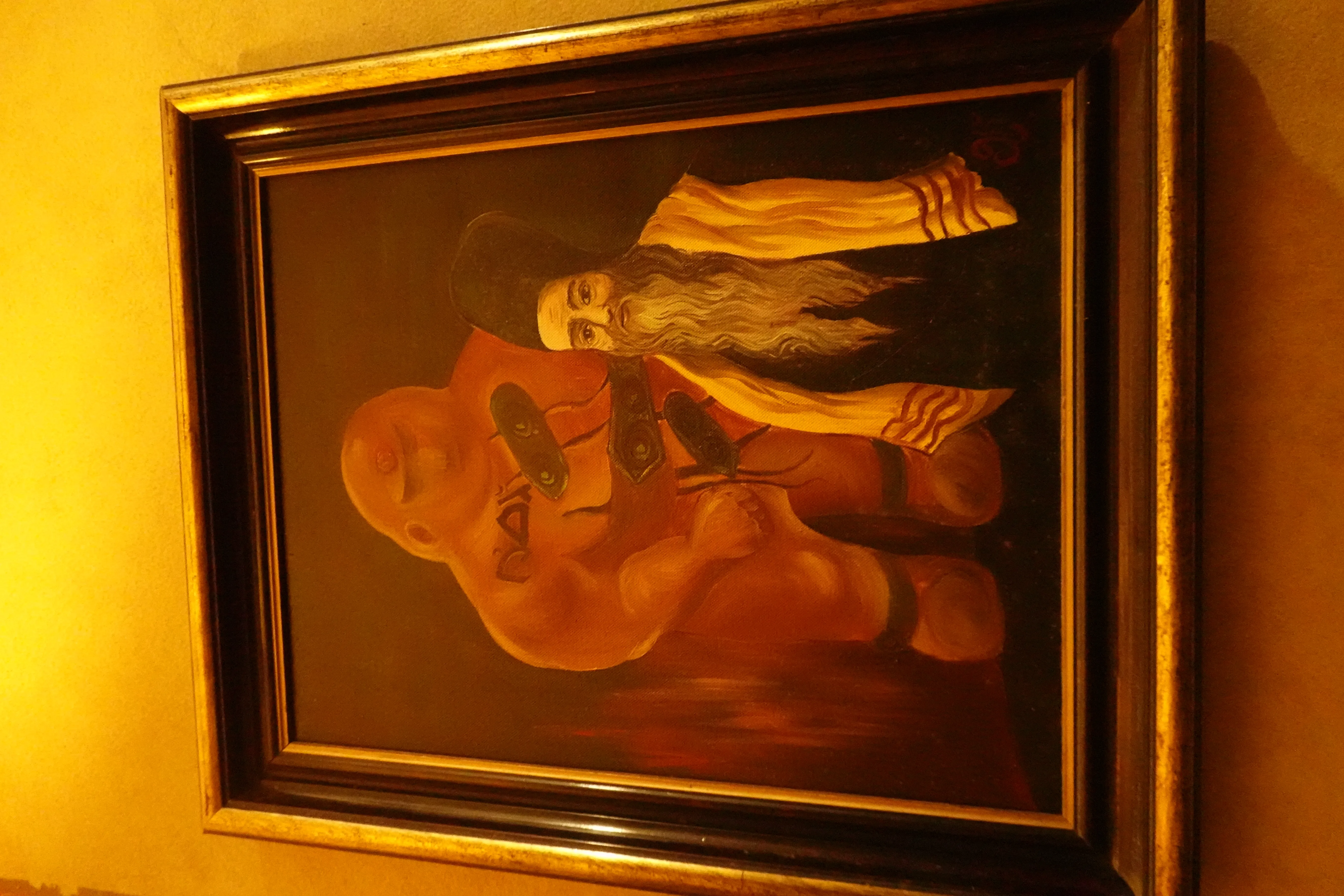 omlijst schilderij van een alchemist met een lange baard en een kale figuur