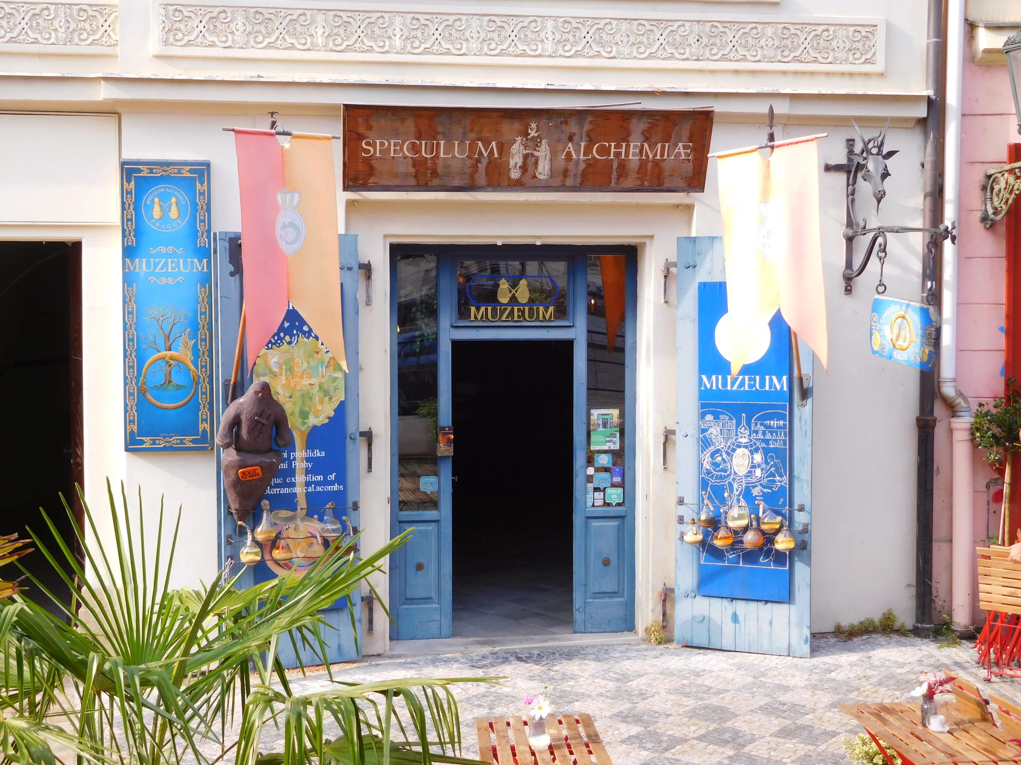 blue doors and banners at the entrance of Speculum Alchemiae museum