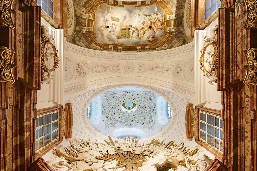Vista interior de la Iglesia de San Carlos con un techo pintado al fresco, detalles ornamentados en dorado y una gran ventana ovalada.