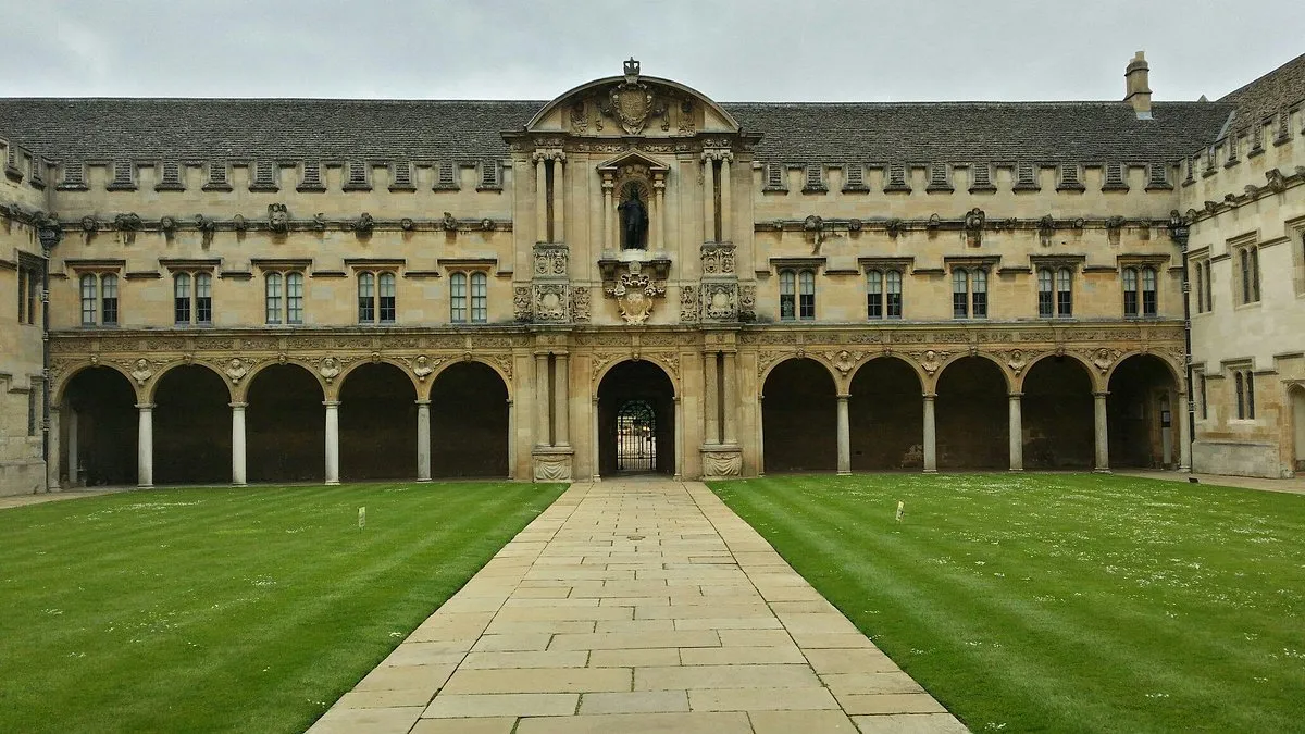 Stenen binnenplaats van St John's College met gewelfde kloostergangen, centrale poorttoren en een strak gazon met een stenen pad