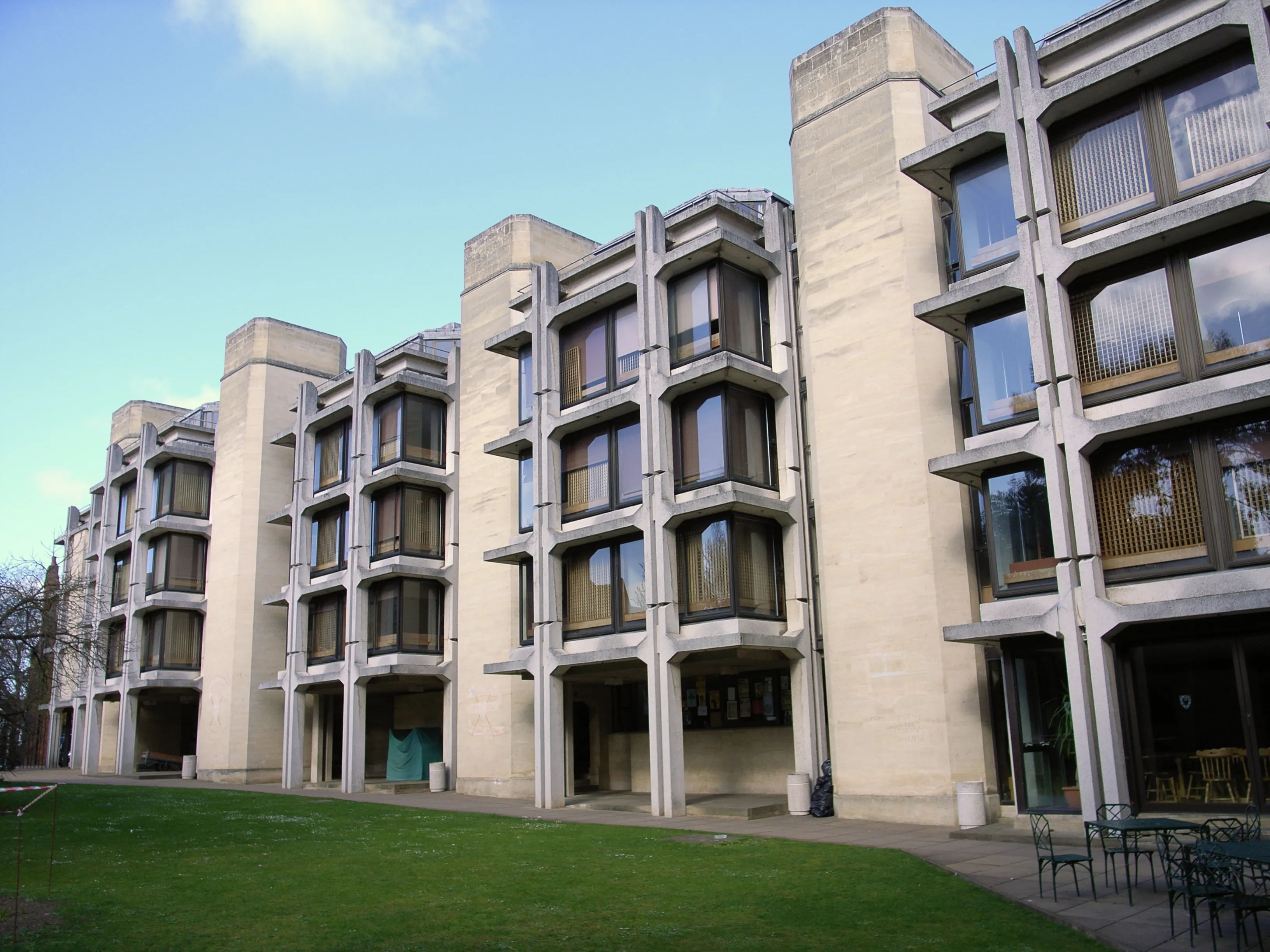 Brutalistyczny betonowy budynek z dużymi oknami i trawnikiem przed nim, Thomas White Quad w St John's College