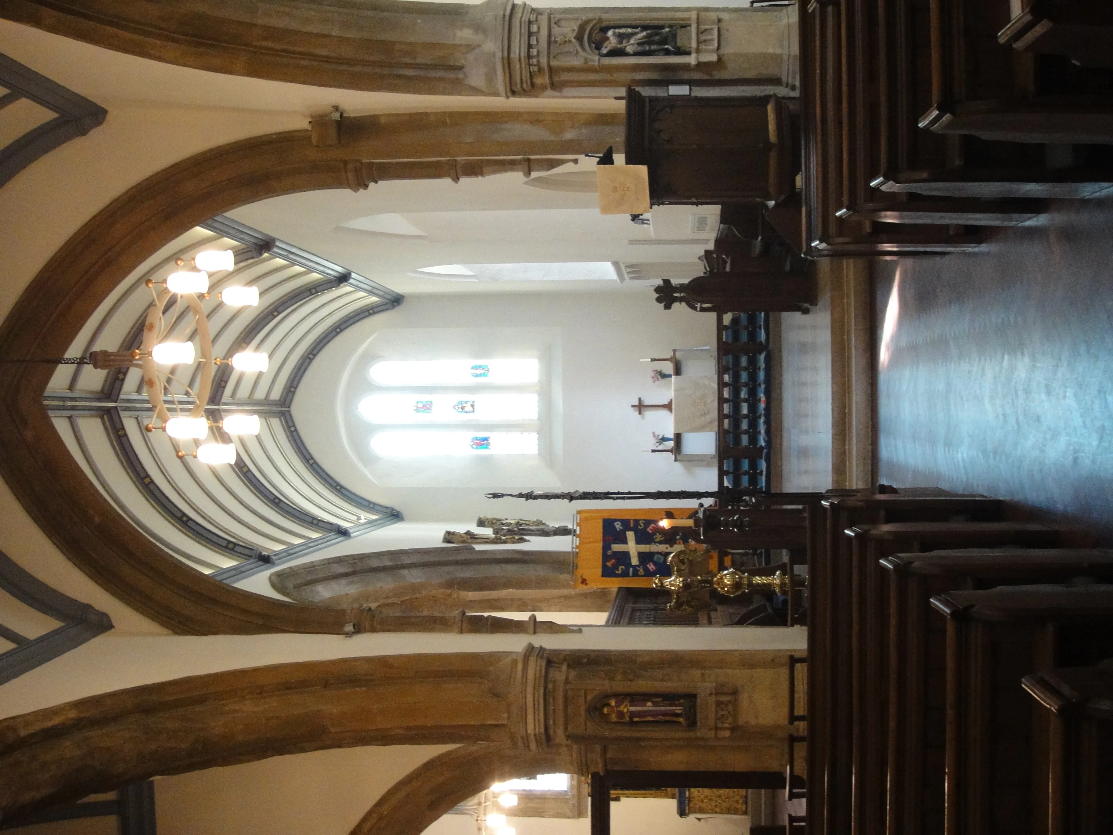 Interieur van de St Michael at the North Gate-kerk met stenen bogen, houten kerkbanken en het altaargedeelte.