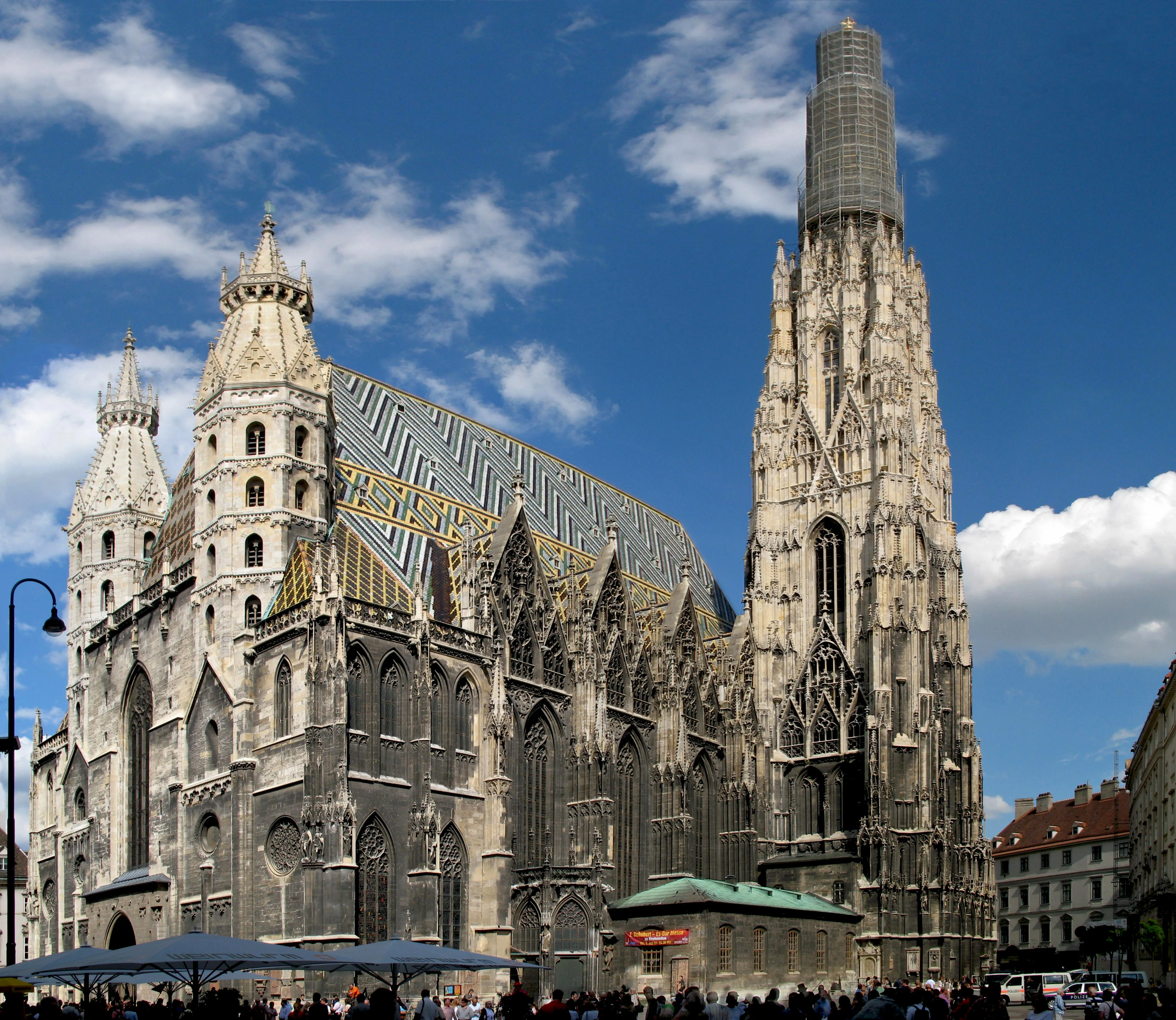 St. Stephen's Cathedral with its Gothic architecture, colorful tiled roof, and tall tower against a blue sky