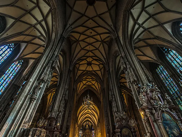 Interior view of St. Stephen's Cathedral with a high vaulted ceiling, stone columns, and stained glass windows