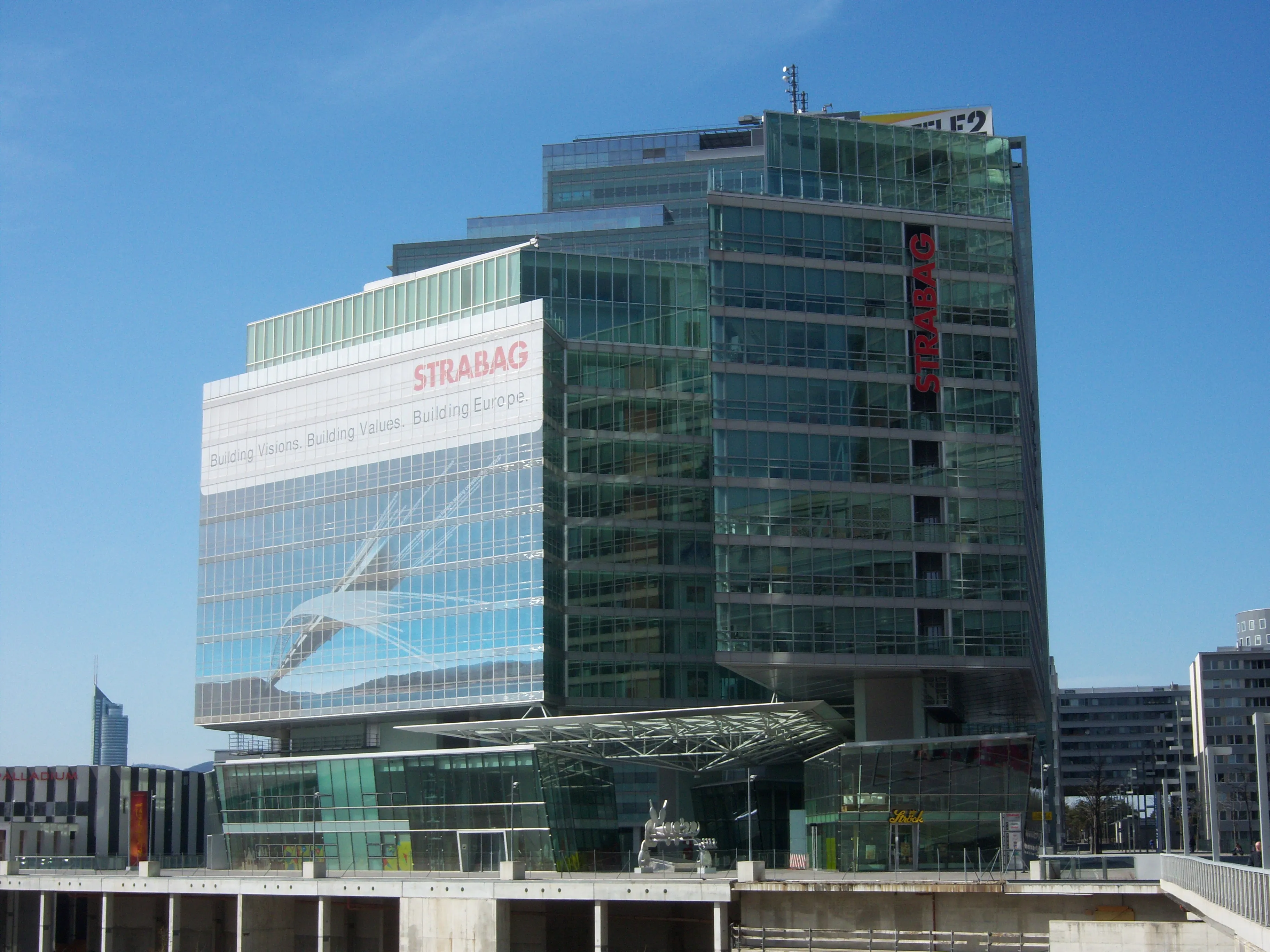 Edificio moderno de cristal con señalización de STRABAG en la fachada