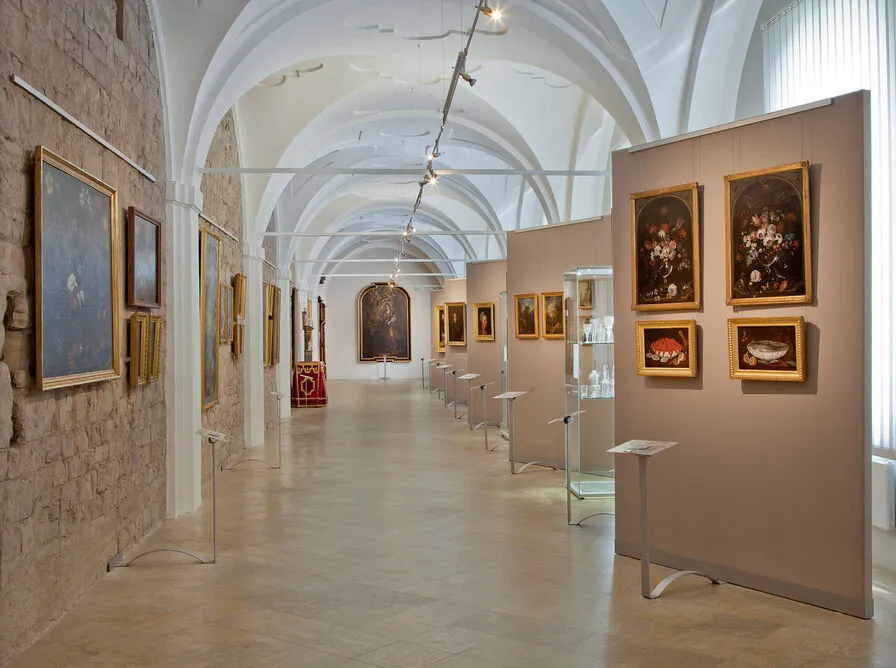 long gallery with arched ceilings and paintings on display