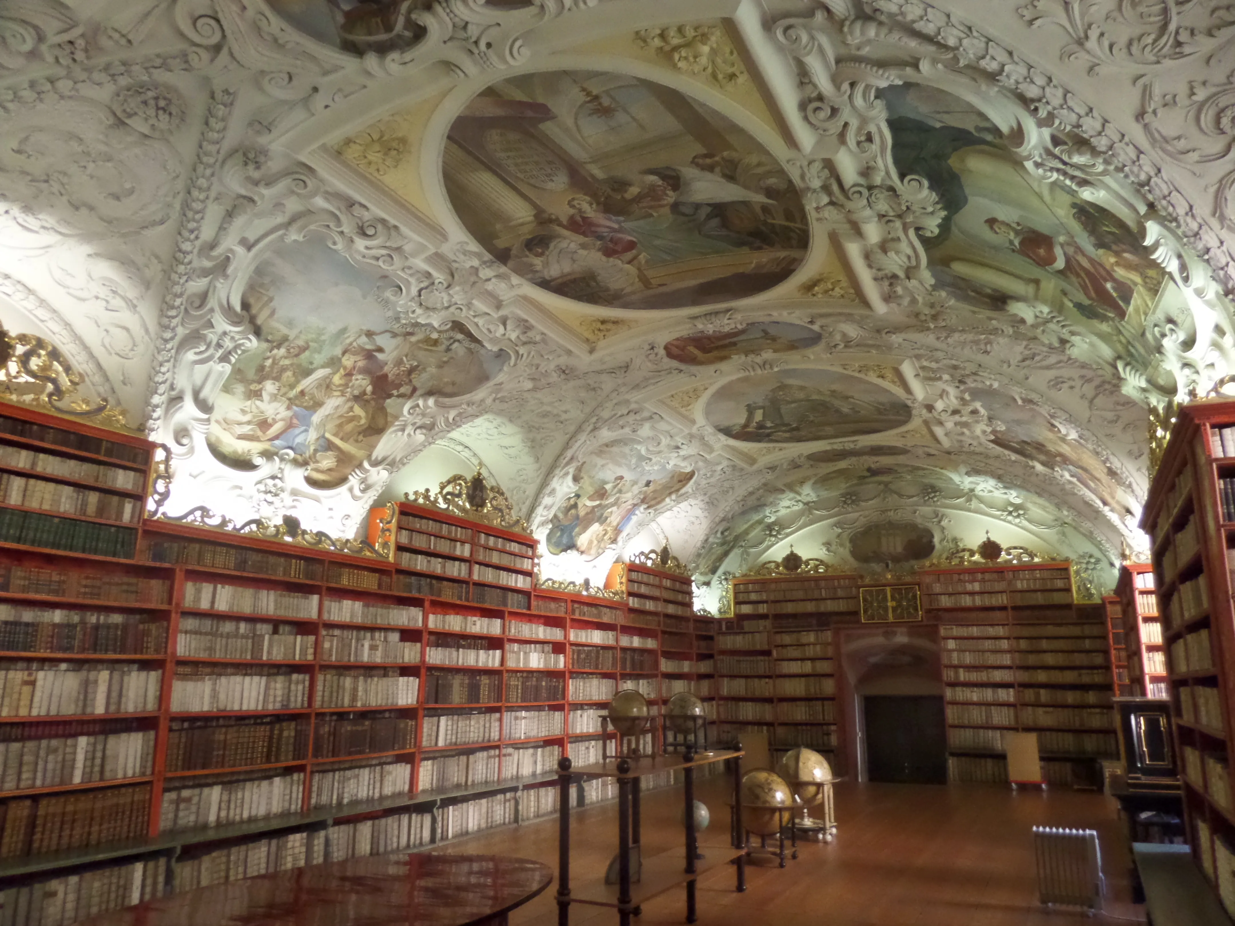 Interior of Strahov Monastery library with ornate ceiling frescoes and bookshelves
