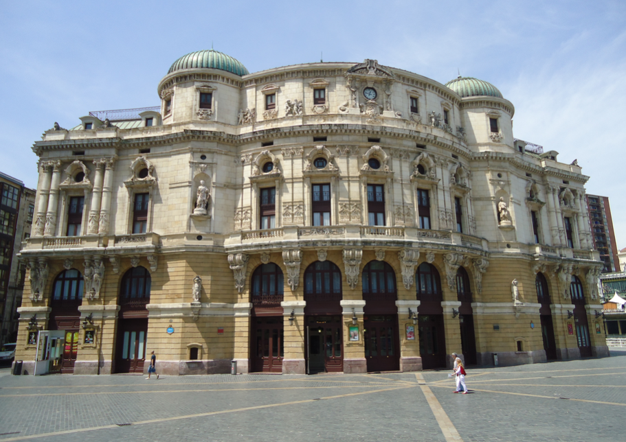 Teatro Arriaga Antzokia, un gran edificio teatral de estilo neobarroco con una fachada ornamentada, ventanas arqueadas y cúpulas verdes, visto desde la plaza.