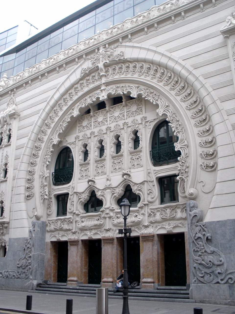 De sierlijke witte art-nouveaugevel van Teatro Campos Elíseos met een grote decoratieve boog, gedetailleerd stucwerk, boogramen en de entree op straatniveau.