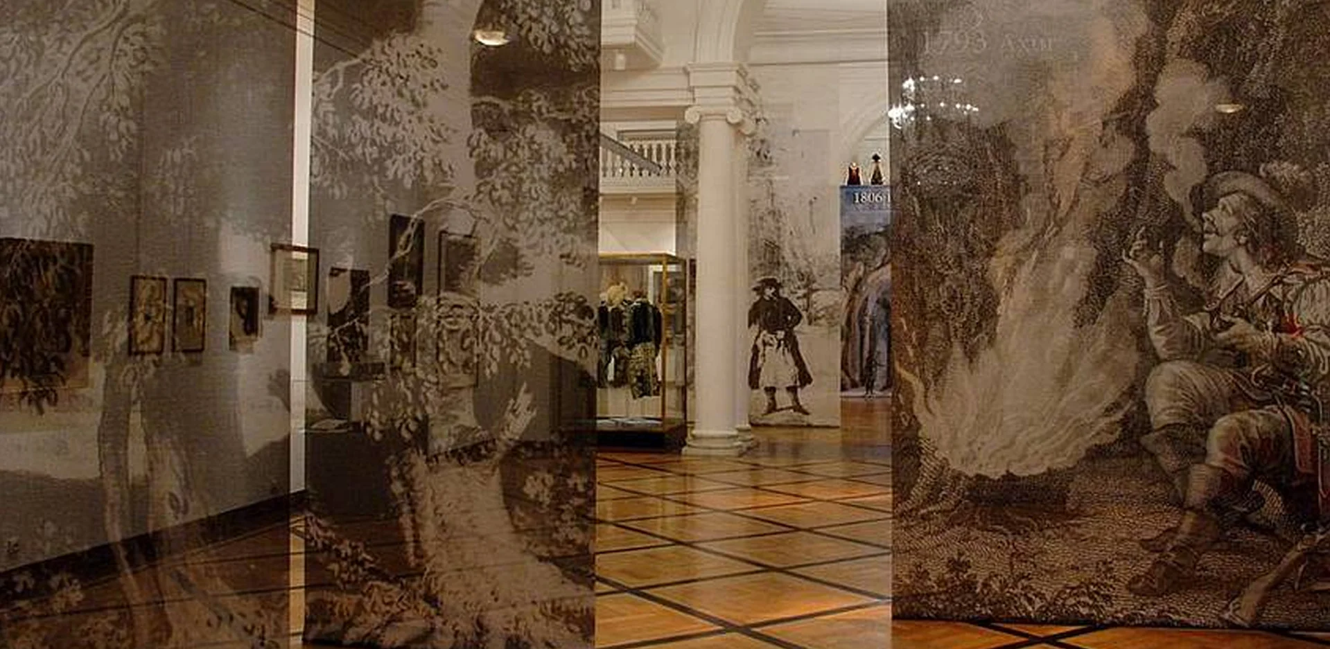 interior of a museum with large theatrical paintings on the walls and a person walking in the distance