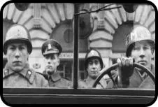 black-and-white film still of four men in military helmets inside a vehicle