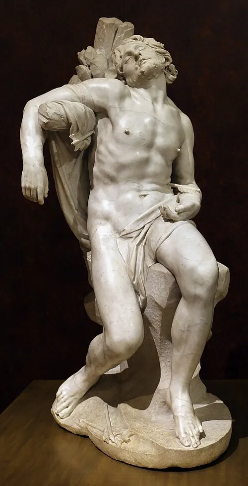 Marmeren beeld van een mannelijke figuur met gedrapeerde doek, zittend op een stenen sokkel