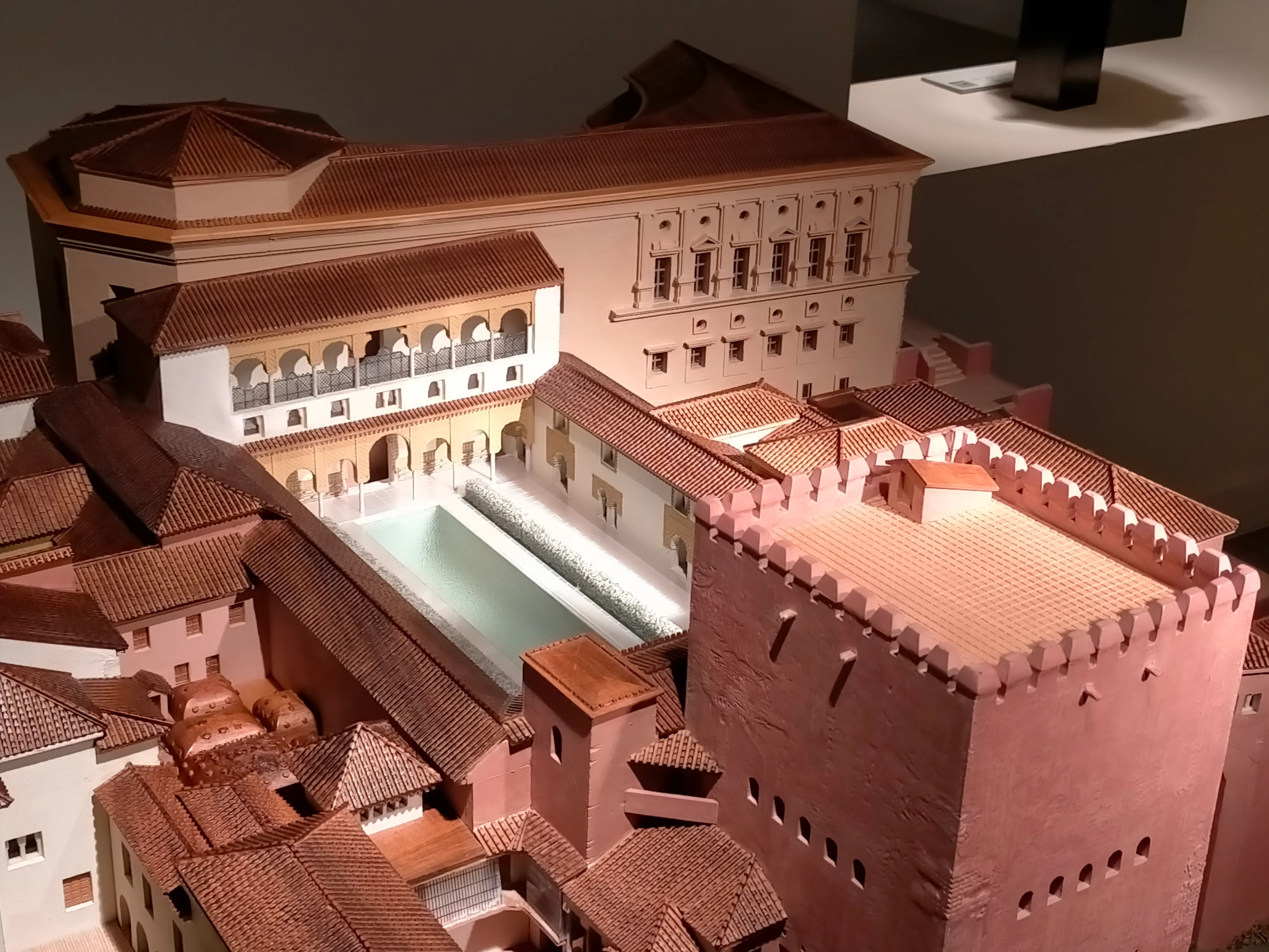Maqueta táctil de un complejo de edificios con patio central y tejados de tejas rojas