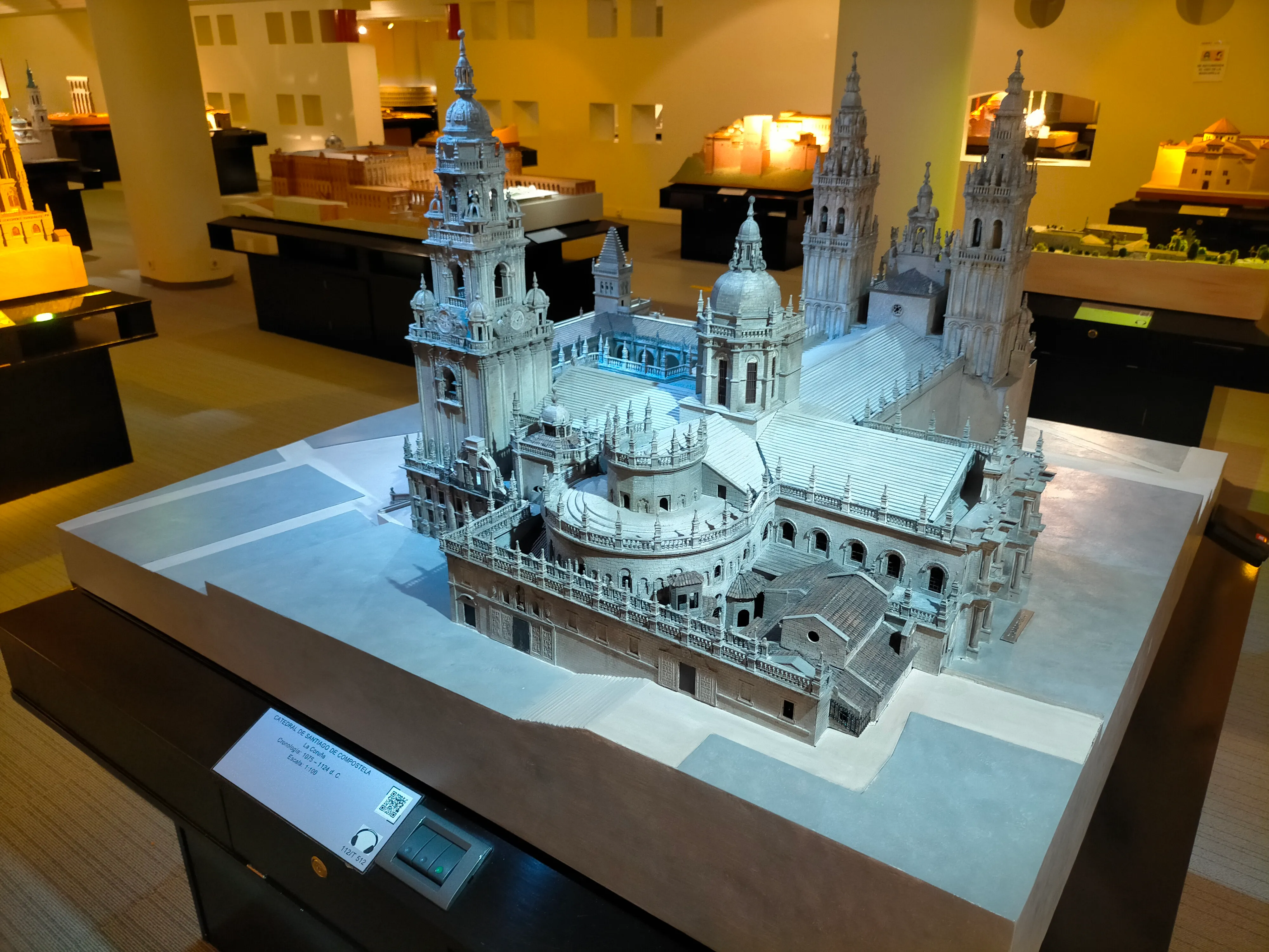 Maqueta táctil de una catedral con agujas y cúpulas sobre una mesa expositora en un museo