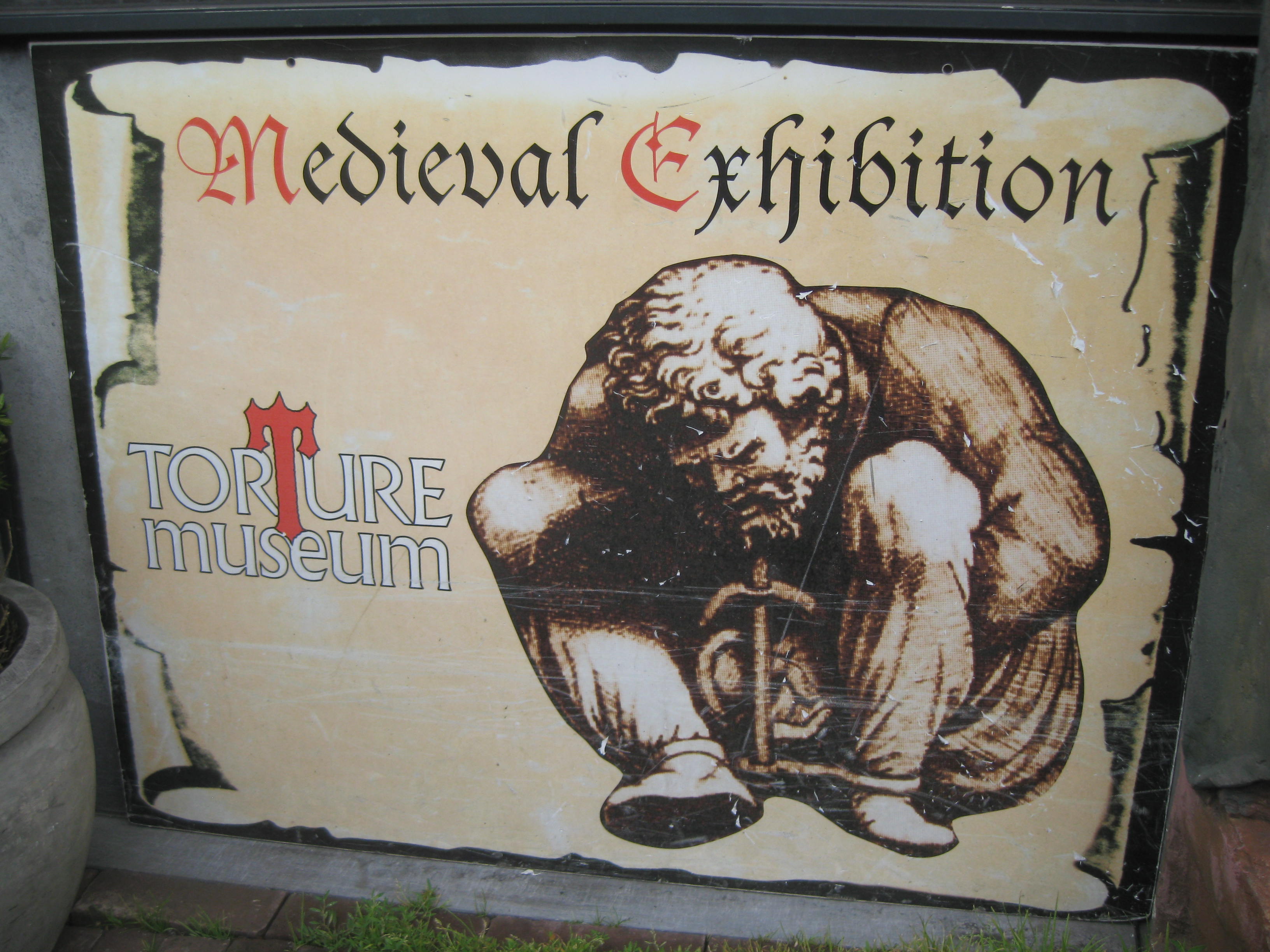 Letrero del Museo de la Tortura de Ámsterdam con el texto 'Exposición Medieval' y un dibujo de un hombre encadenado